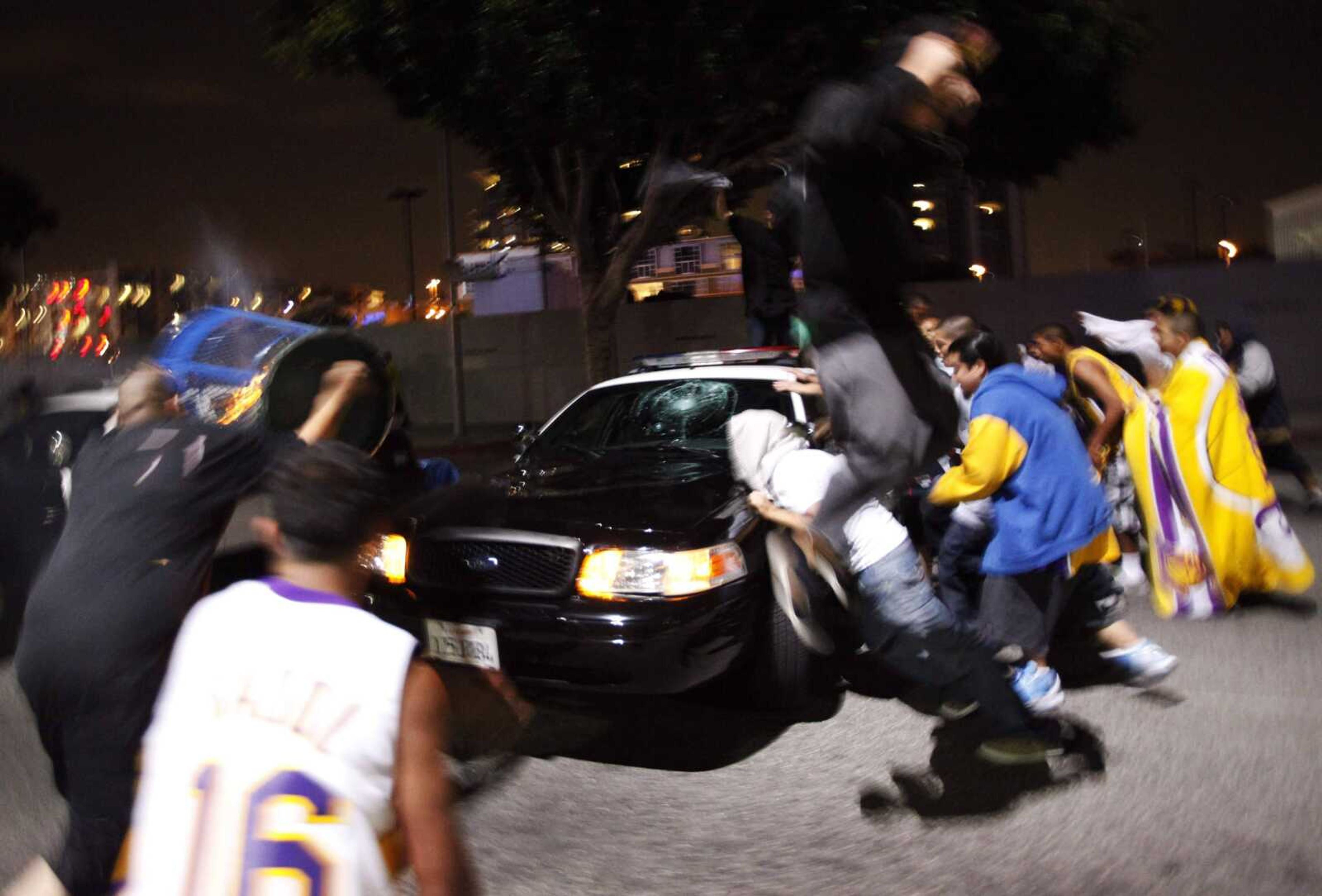 Vandals broke the windshield and try to flip a police car Sunday in Los Angeles after the Los Angeles Lakers defeated the Orlando Magic in the NBA Finals in Orlando, Fla. (PHILIP SCOTT ANDREWS ~ Associated Press)