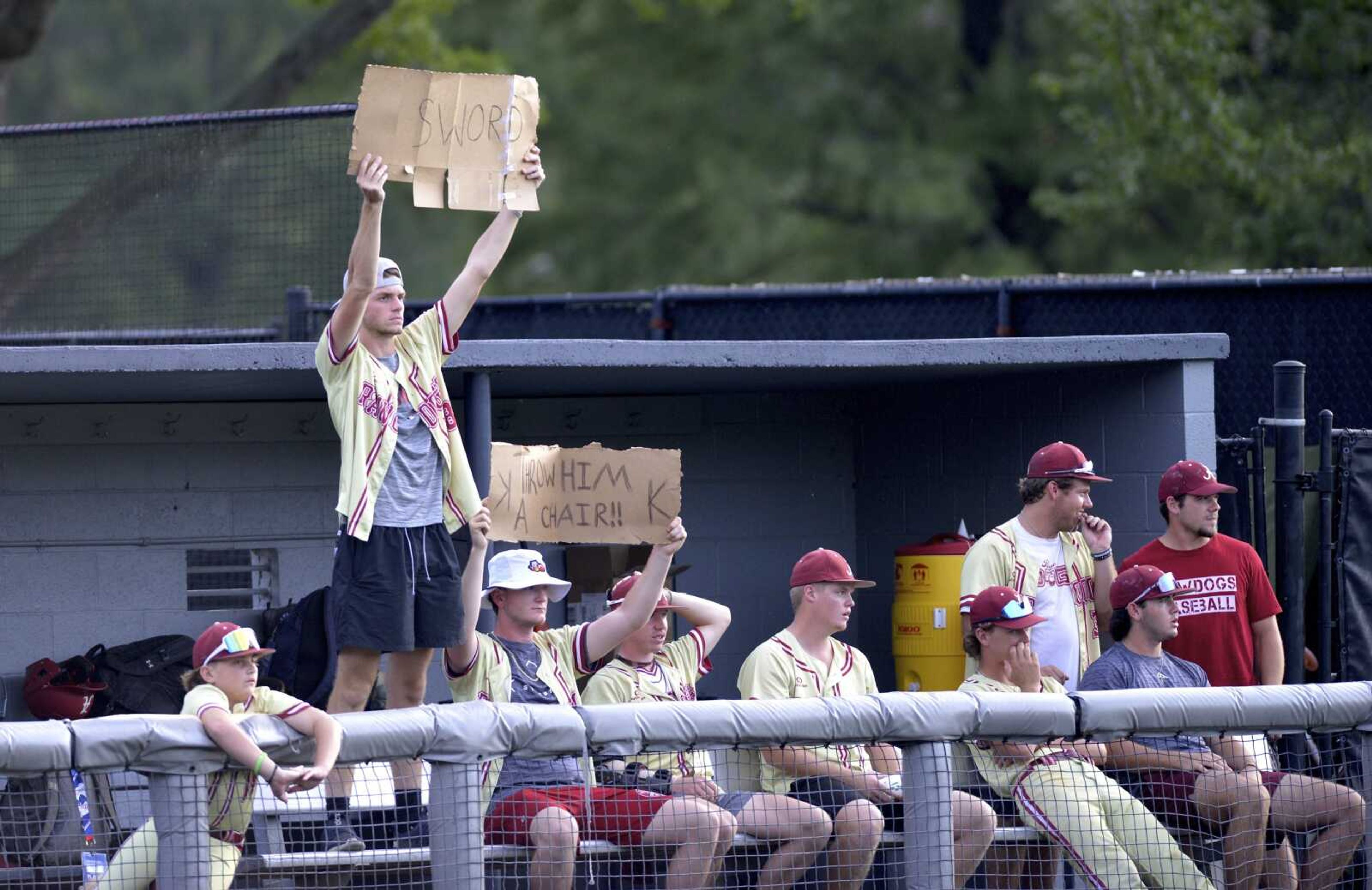 Alabama Rawdogs players who were ruled ineligible because of age and/or college participation, hold signs in support of their teammates during a 5-3 win over Washington at the Babe Ruth World Series on Aug. 17 at Capaha Field in Cape Girardeau.