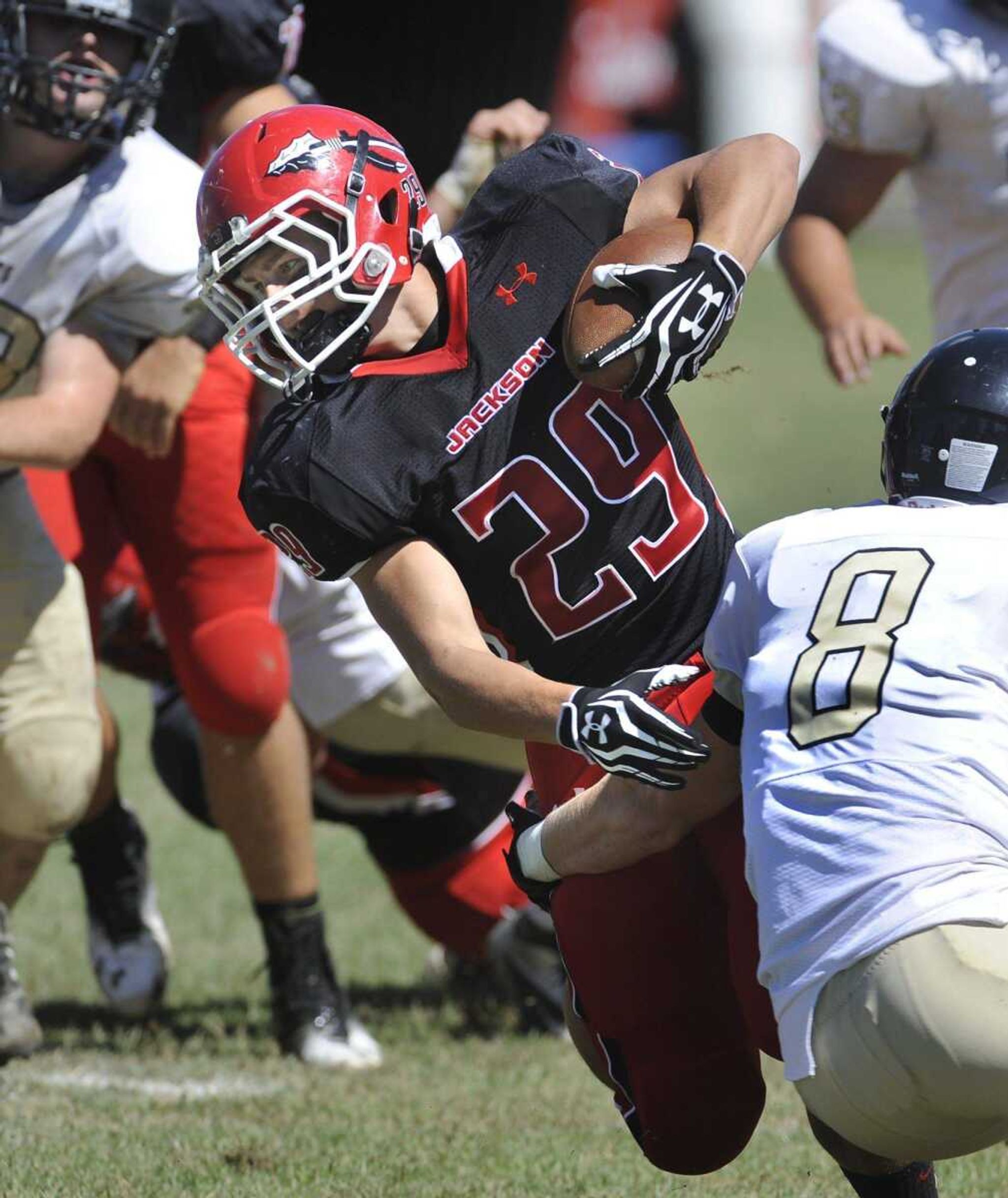 Jackson's Colten Proffer rushes against Farmington's Grant Hopkins during the first quarter Saturday, Sept. 8, 2012 at Jackson High School. (Fred Lynch)