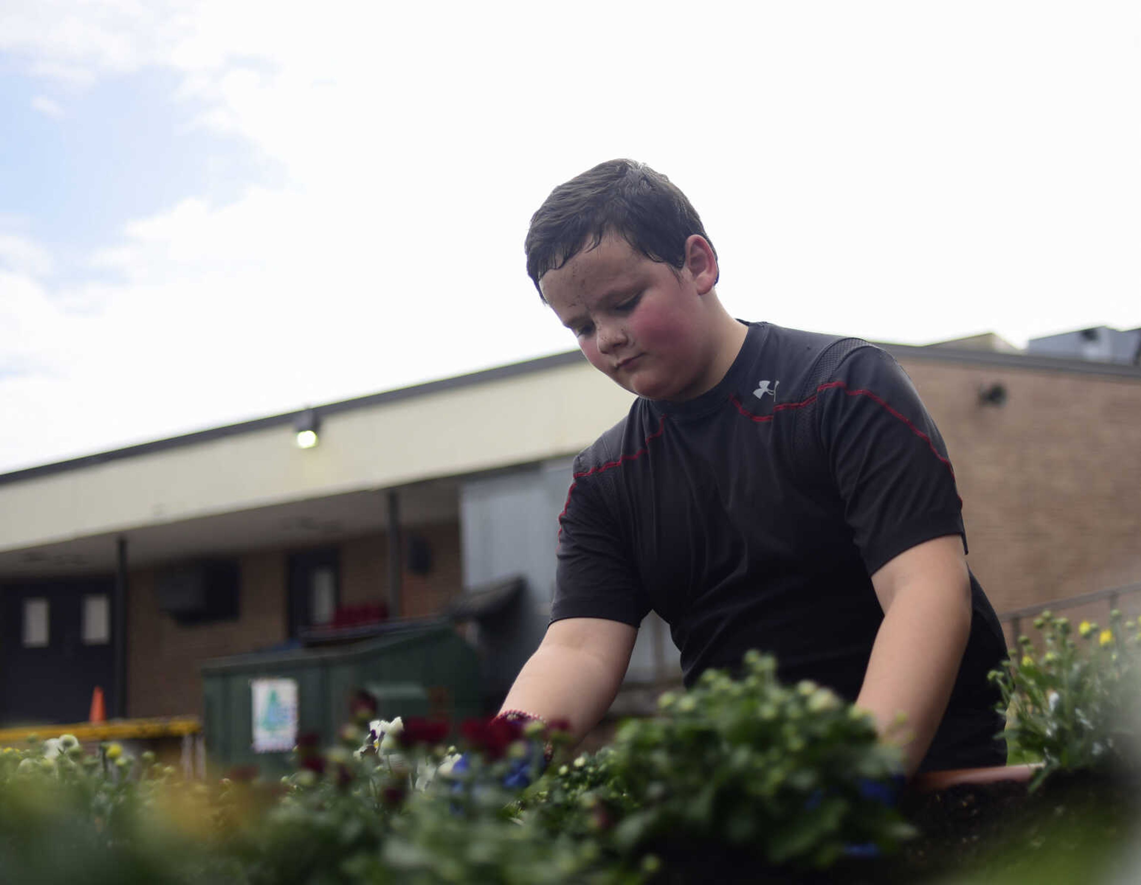 Matthew Brees plants pansies and mums in flower beds donated by Lowe's as part of the Lowe's Heroes program Monday, Sept. 18, 2017 at West Lane Elementary in Jackson. Lowe's donated 12 flower beds, 10 picnic tables and three new benches for the school.