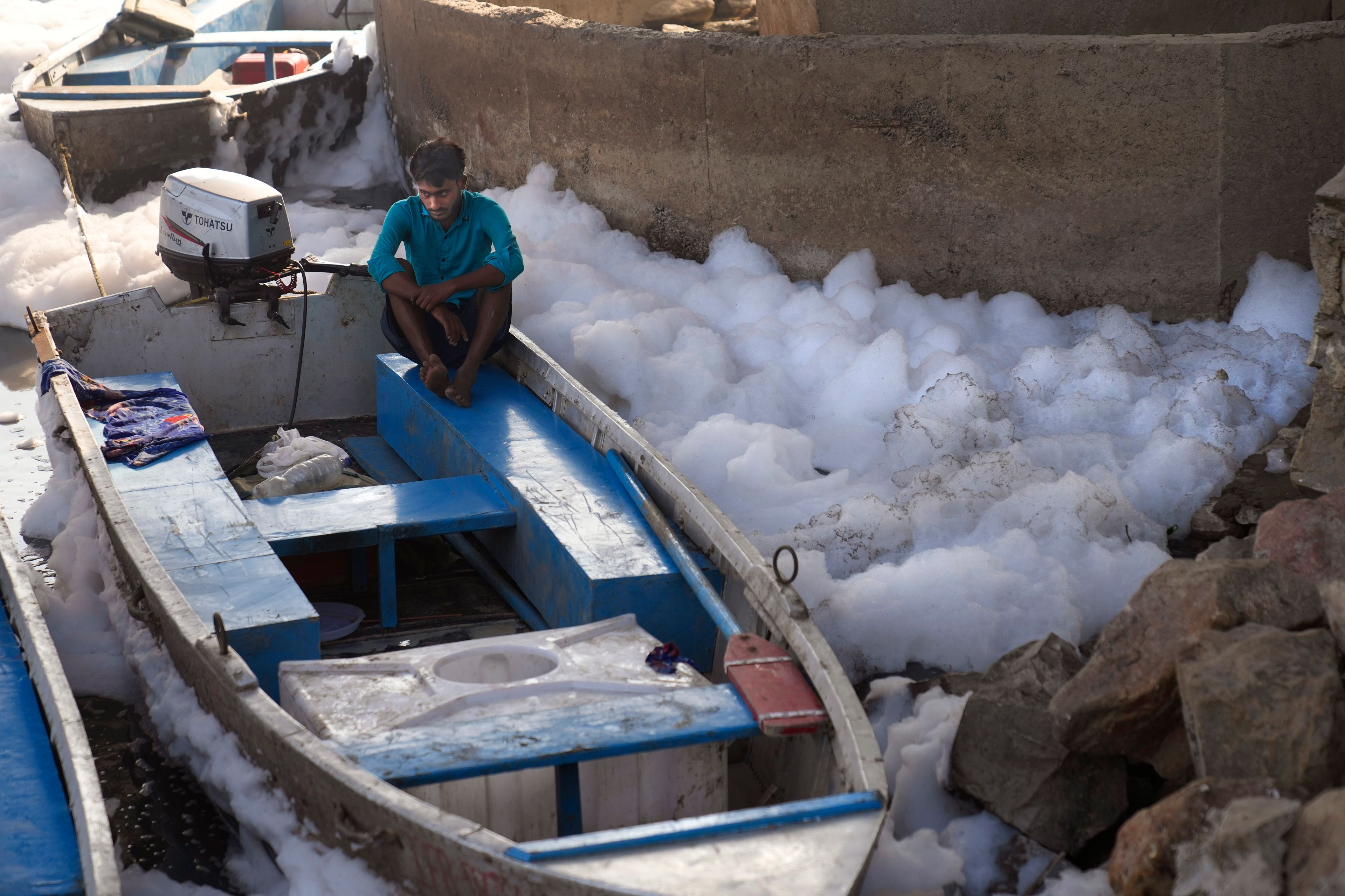 A worker for the Delhi Jal or water board sits in his boat in the river Yamuna filled with toxic foams in New Delhi, India, Tuesday, Oct. 29, 2024. (AP Photo/Manish Swarup)