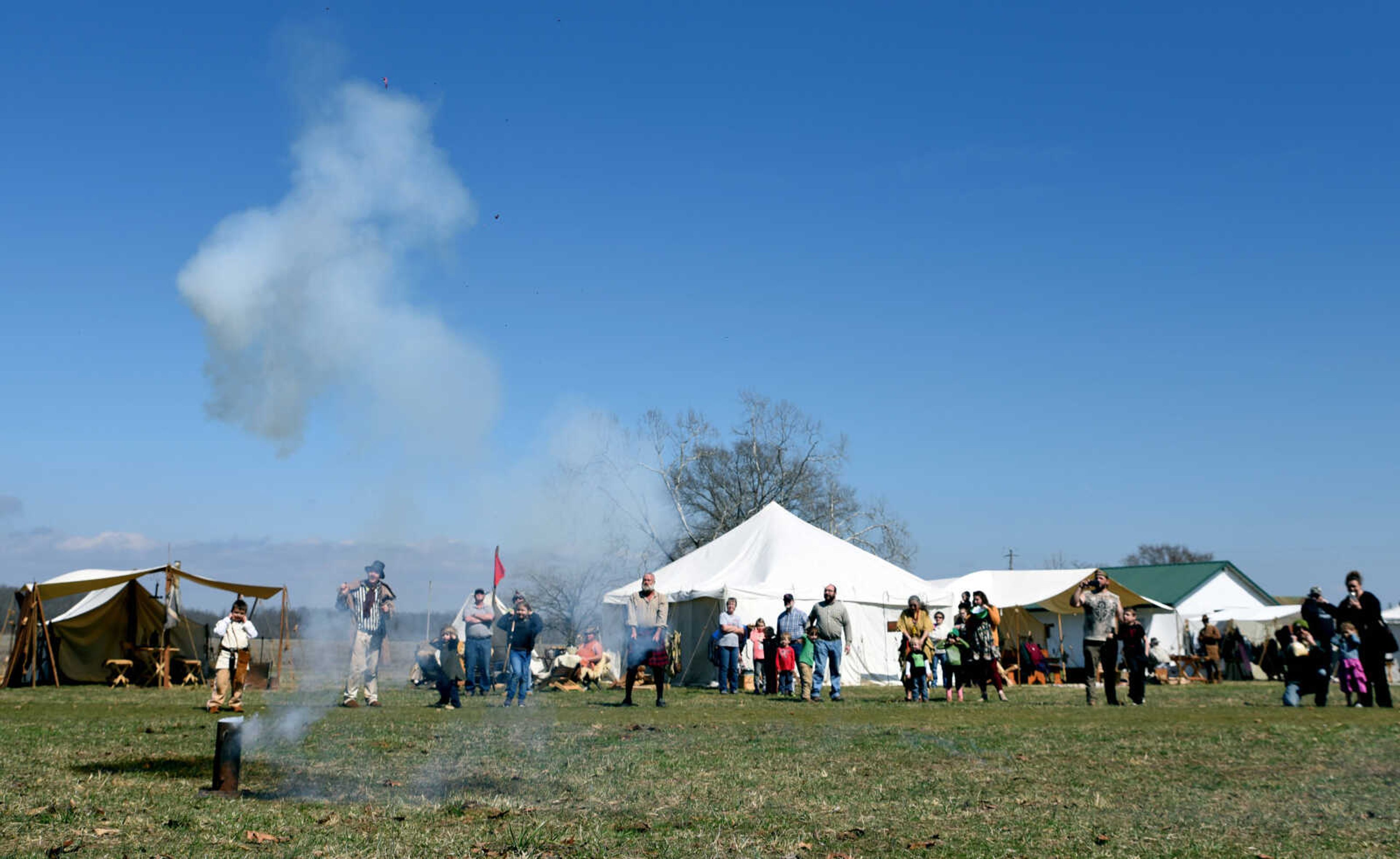 Kids and adults look up as candy falls from the sky as part of the "candy cannon" at the second annual Eastern Ozark Rendezvous held at Bark's Planation Saturday, March 17, 2018, in Glenallen.