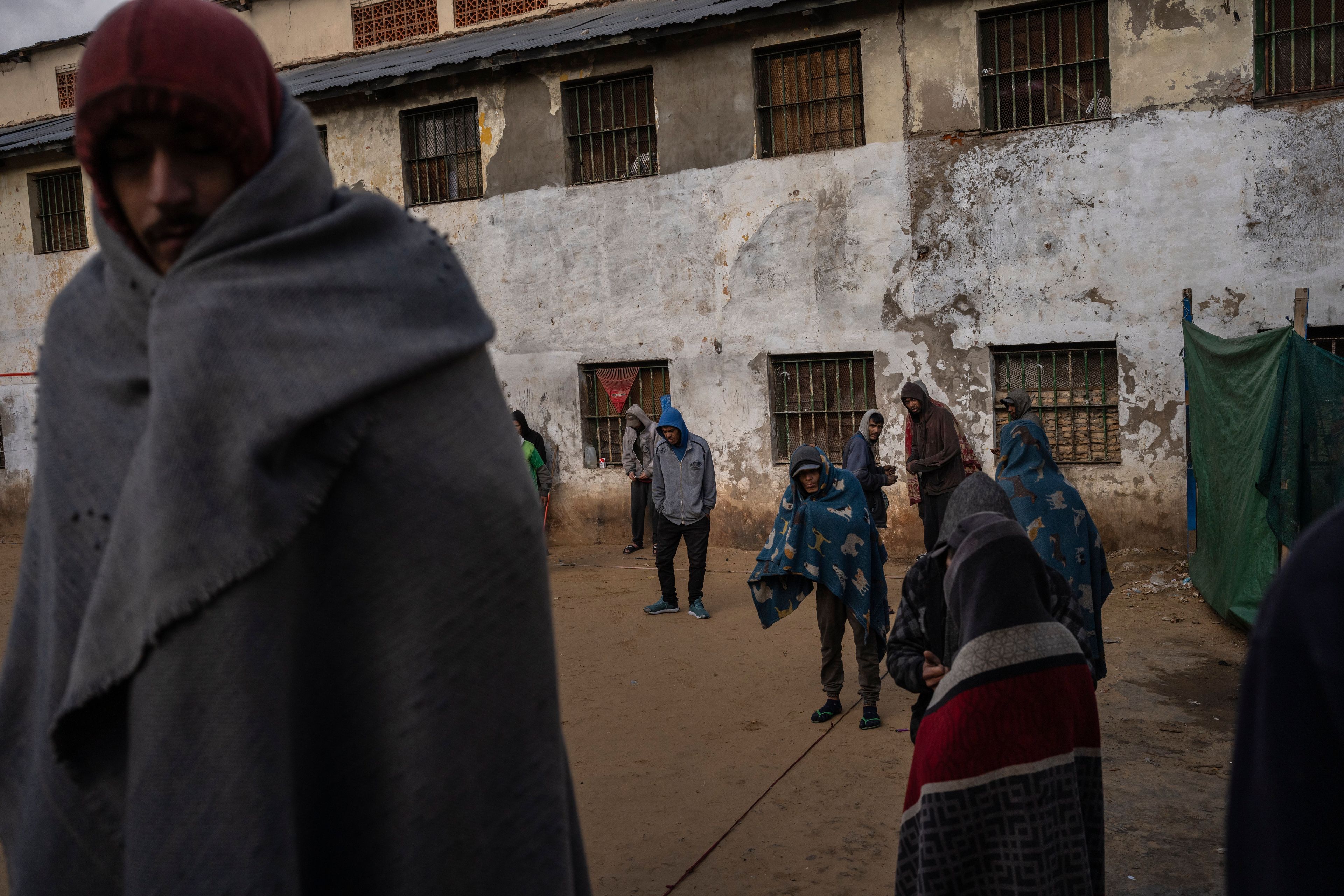 Prisoners keep warm with blankets in the courtyard of the Tacumbu prison in Asuncion, Paraguay, Monday, July 9, 2024. Prisoners are allowed to be outside of their cellblocks until 4pm. (AP Photo/Rodrigo Abd)