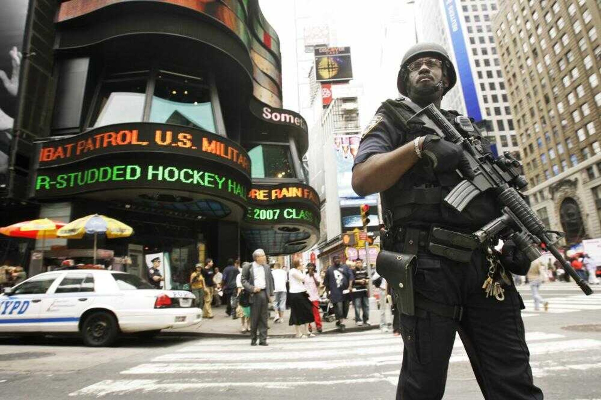 A heavily armed member of the New York Police Department  patroled Times Square on Friday in New York. New York strengthened its already-tight security as a precaution after a bomb threat in London, putting additional police in Times Square and the mass transit system, officials said. (NY MARY ALTAFFER ~ Associated Press)