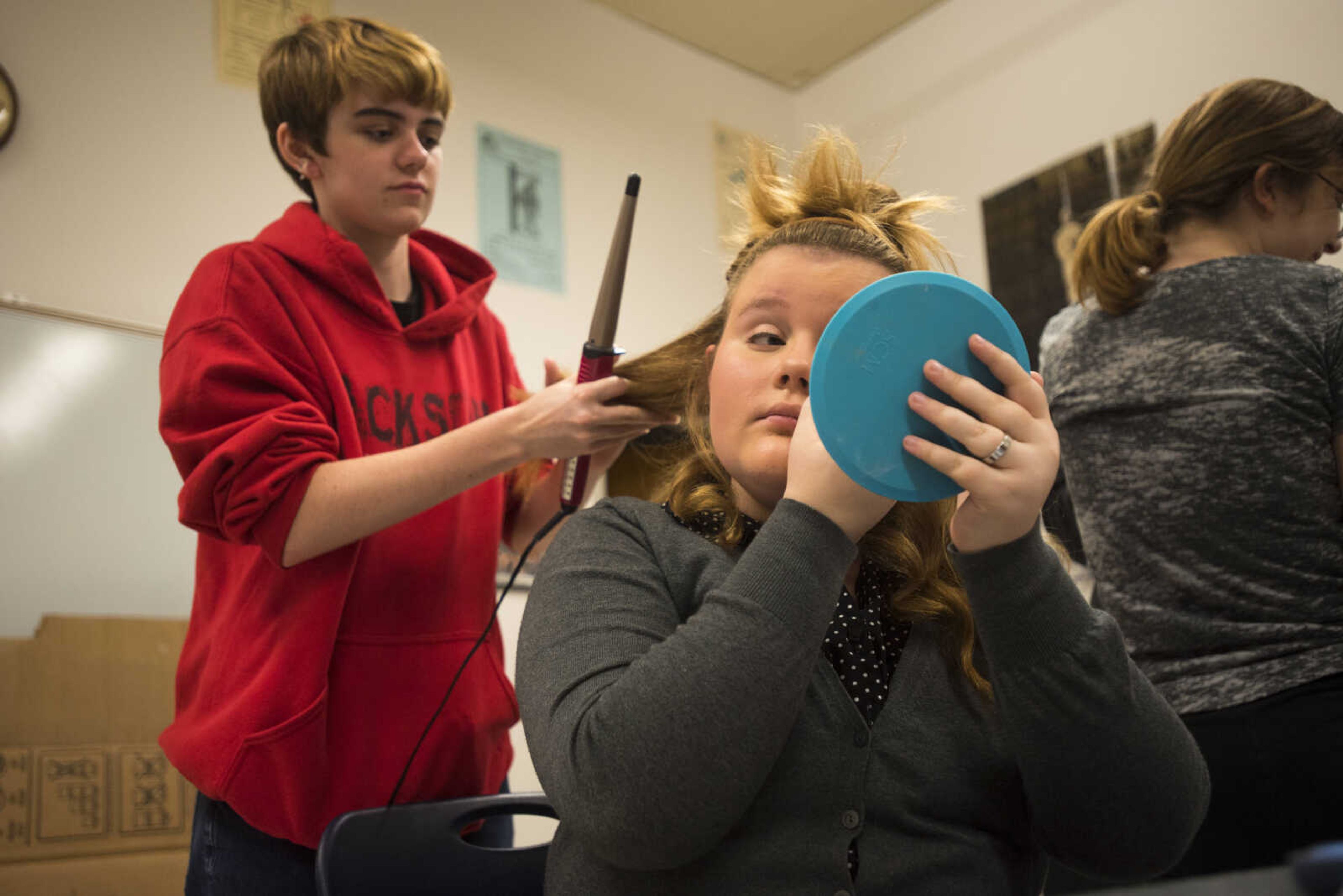 Stage manager Jake Todd, left, helps Eva Clubbs with hair and makeup backstage before the start of dress rehearsal for Jackson's fall play, "The Curious Savage" Oct. 10, 2017 at Jackson High School.