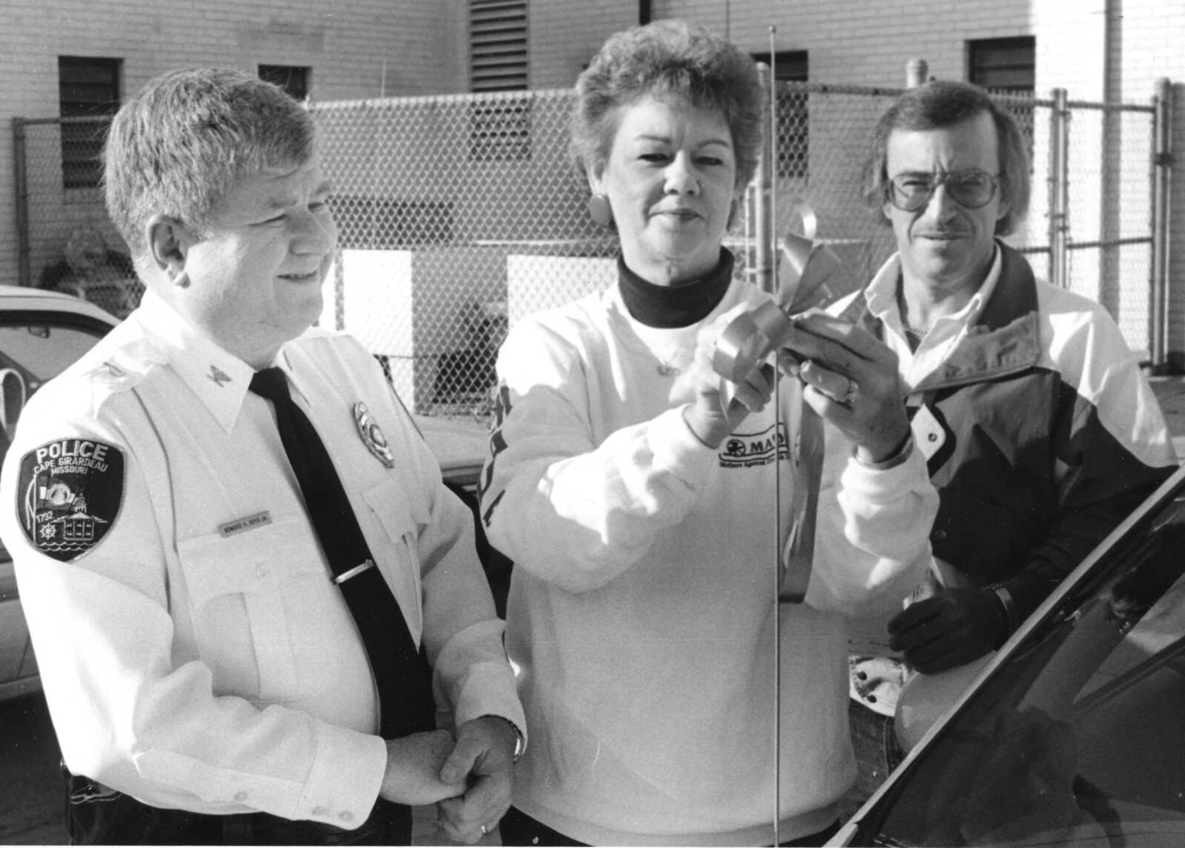 Published Dec. 9, 1992.
Judy Dambach, a member of Mothers Against Drunk Driving, attaches a red ribbon to a police car antenna at the Cape Girardeau Police Department with Police Chief Howard "Butch" Boyd, left, and Al King of Procter & Gamble which donated 15,000 ribbons for the project. The ribbons are a reminder not to drink and drive. (Southeast Missourian archive)