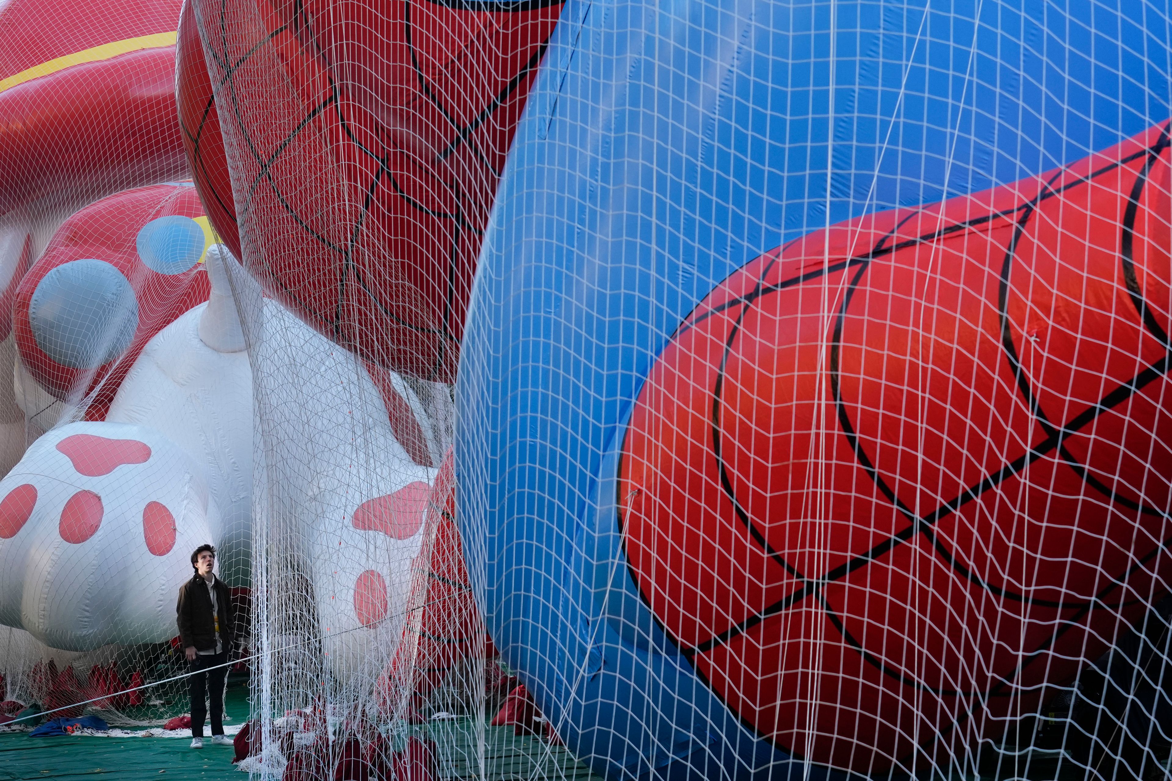 A man looks up at floats being prepared for the Macy's Thanksgiving Day Parade in New York, Wednesday, Nov. 27, 2024. (AP Photo/Seth Wenig)