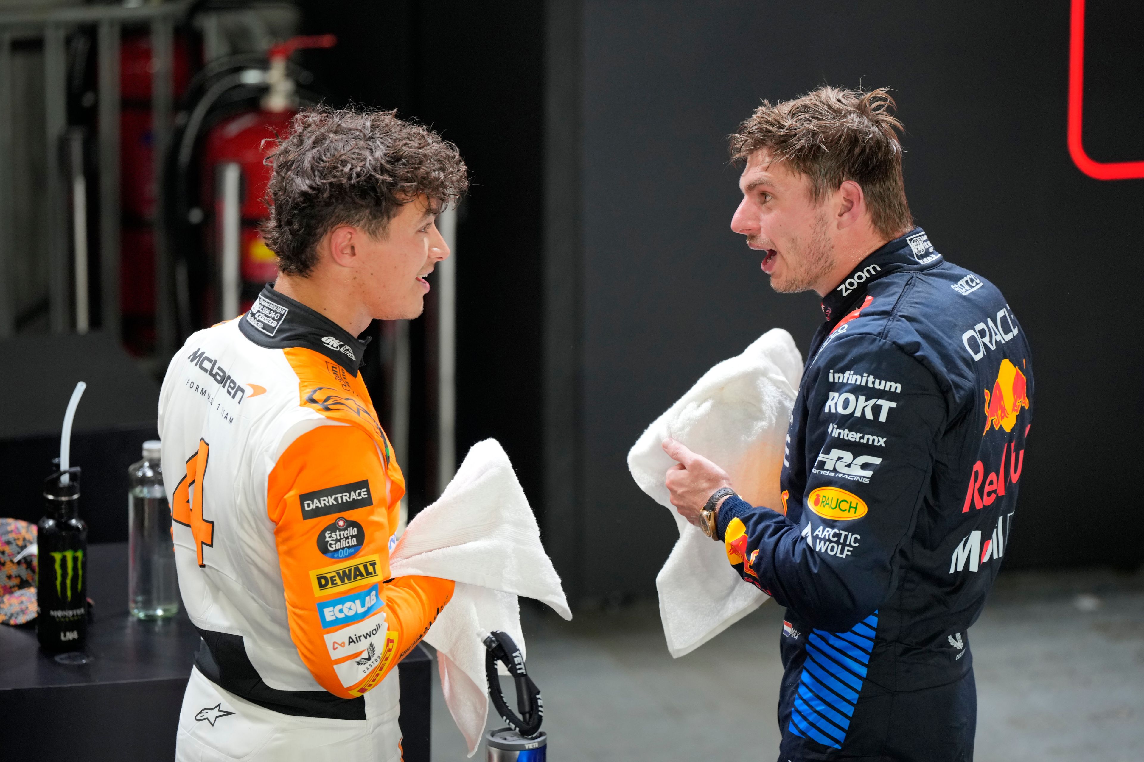 McLaren driver Lando Norris of Britain, left, talks with second placed Red Bull driver Max Verstappen of the Netherlands after qualifying session of the Singapore Formula One Grand Prix at the Marina Bay Street Circuit, in Singapore, Saturday, Sept. 21, 2024. (AP Photo/Vincent Thian)