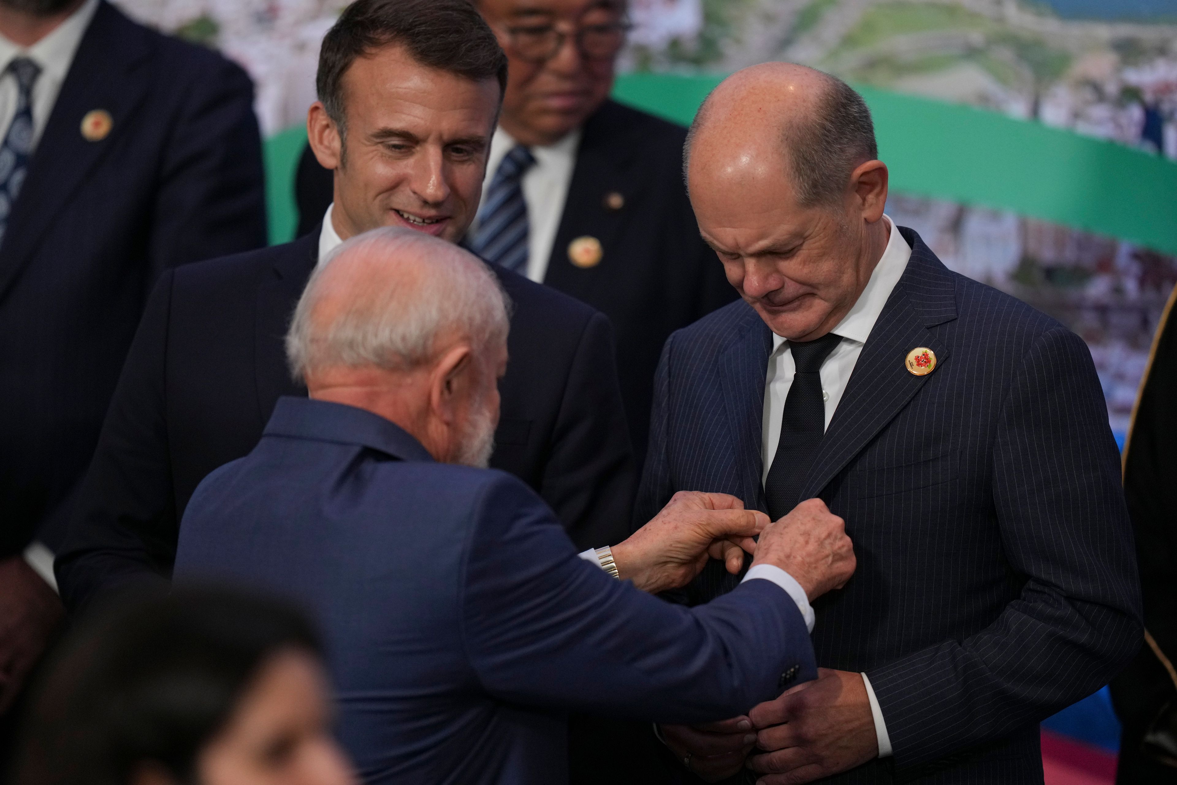 Brazil's President Luiz Inacio Lula da Silva straightens the lapels of Germany's Chancellor Olaf Scholz as they gather for a Group 20 Summit world leaders' group photo, in Rio de Janeiro, Tuesday, Nov. 19, 2024. (AP Photo/Silvia Izquierdo)