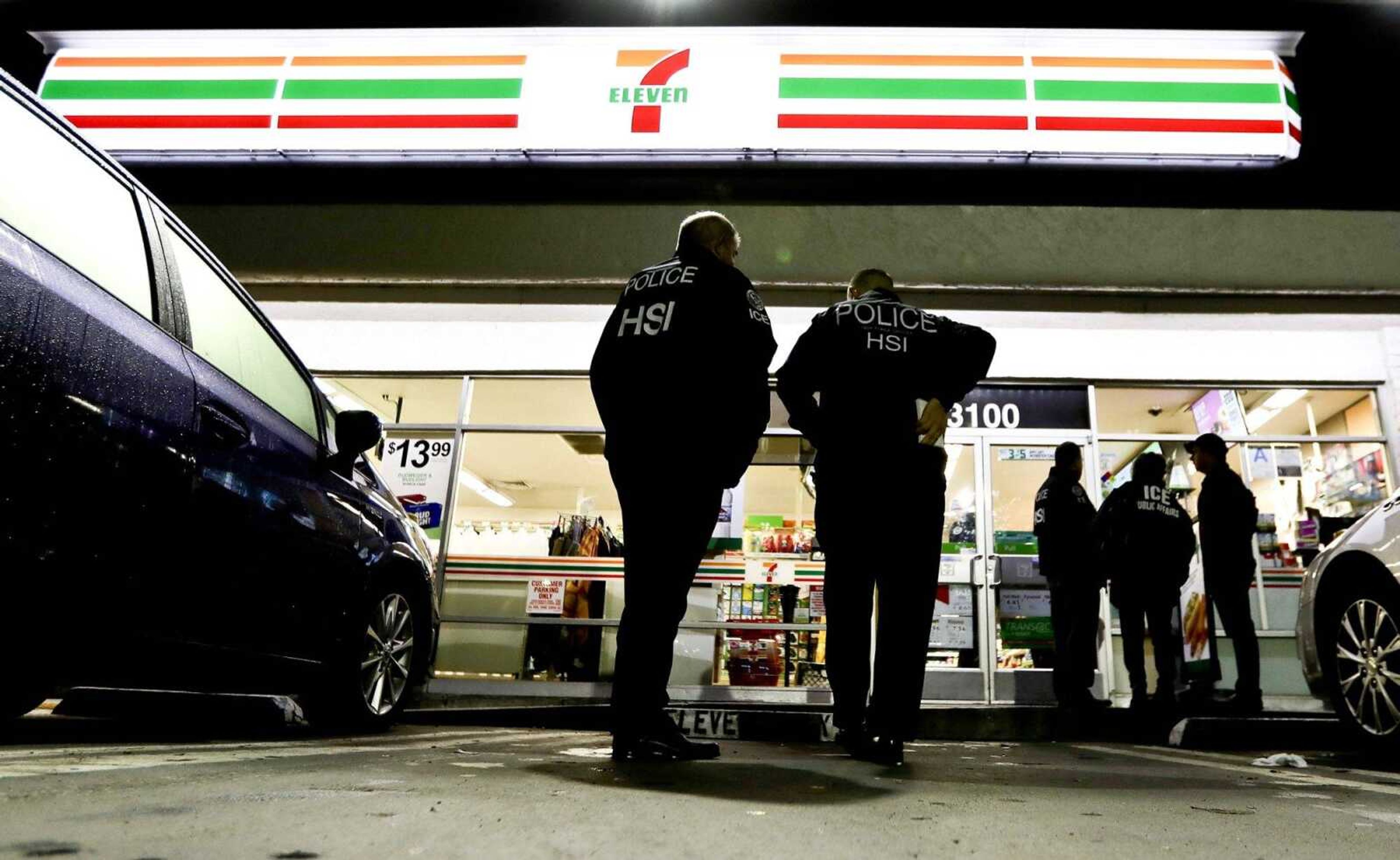 U.S. Immigration and Customs Enforcement, ICE agents serve an employment audit notice at a 7-Eleven convenience store in January in Los Angeles. A federal judge has dismissed the federal government's claim U.S. law trumps two California laws intended to protect immigrants who are in the country illegally.