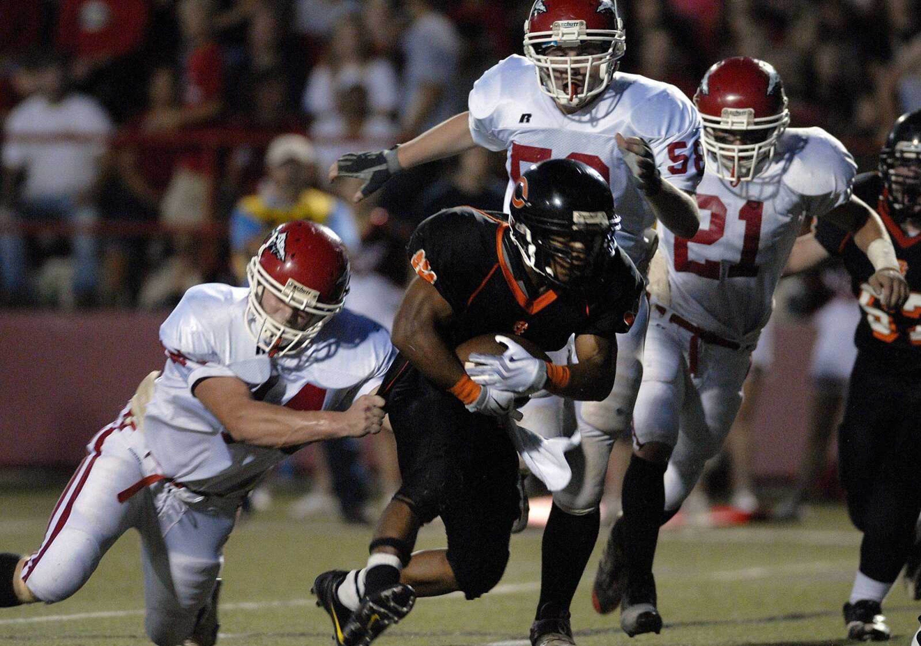 Jackson defenders Ben Mickan, left, Wes Dillard, center, and Austin Gonzaque chase down Central running back James Poindexter during Friday's game at Houck Stadium. The Tigers beat the Indians for the first time since 2002. (Laura Simon)