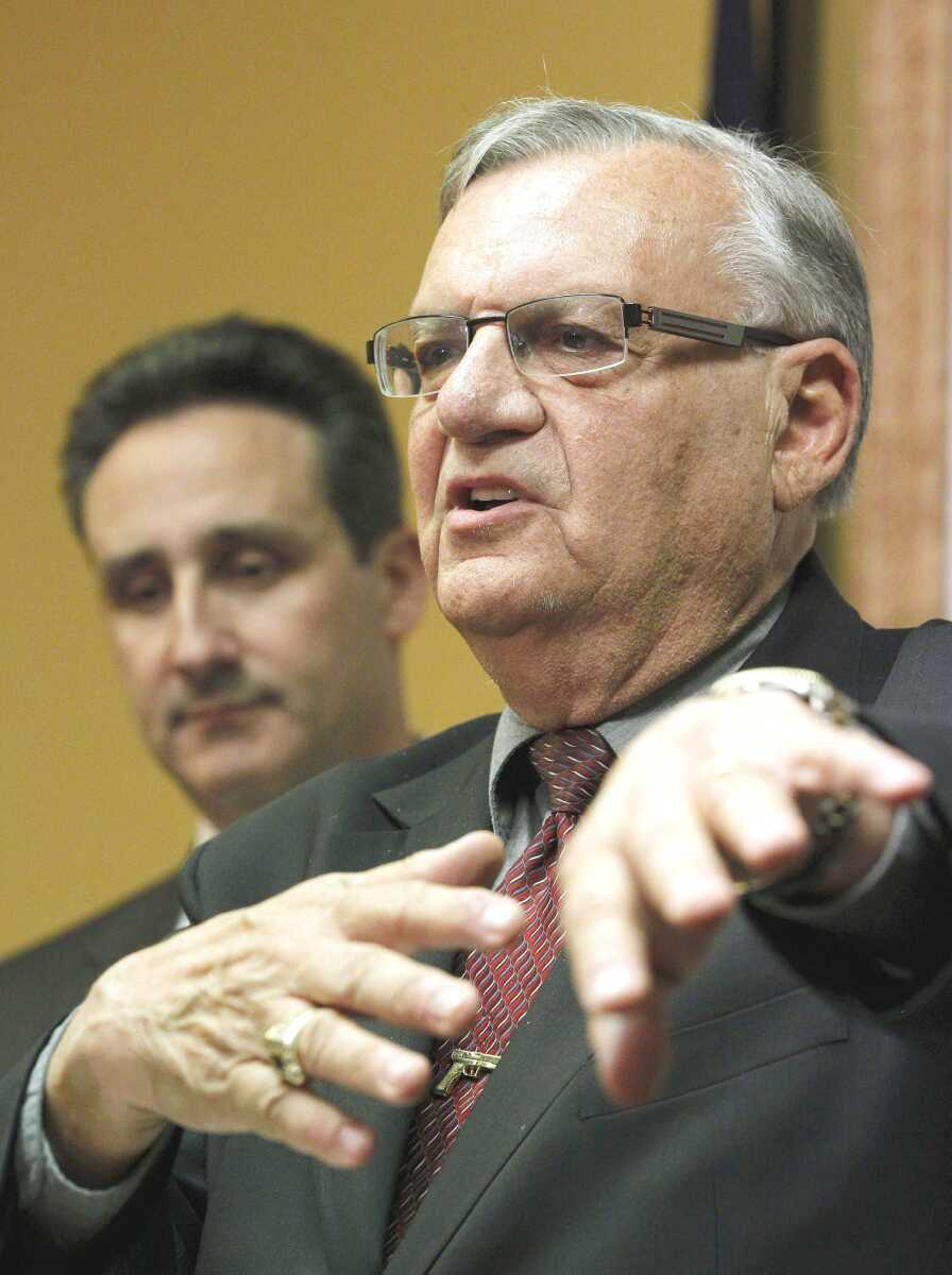 With one of his attorneys, Joseph Popolizio, listening, Maricopa County Sheriff Joe Arpaio answers questions regarding a lawsuit filed against him and his department by the Department of Justice during a news conference Thursday in Phoenix. (Ross D. Franklin ~ Associated Press)