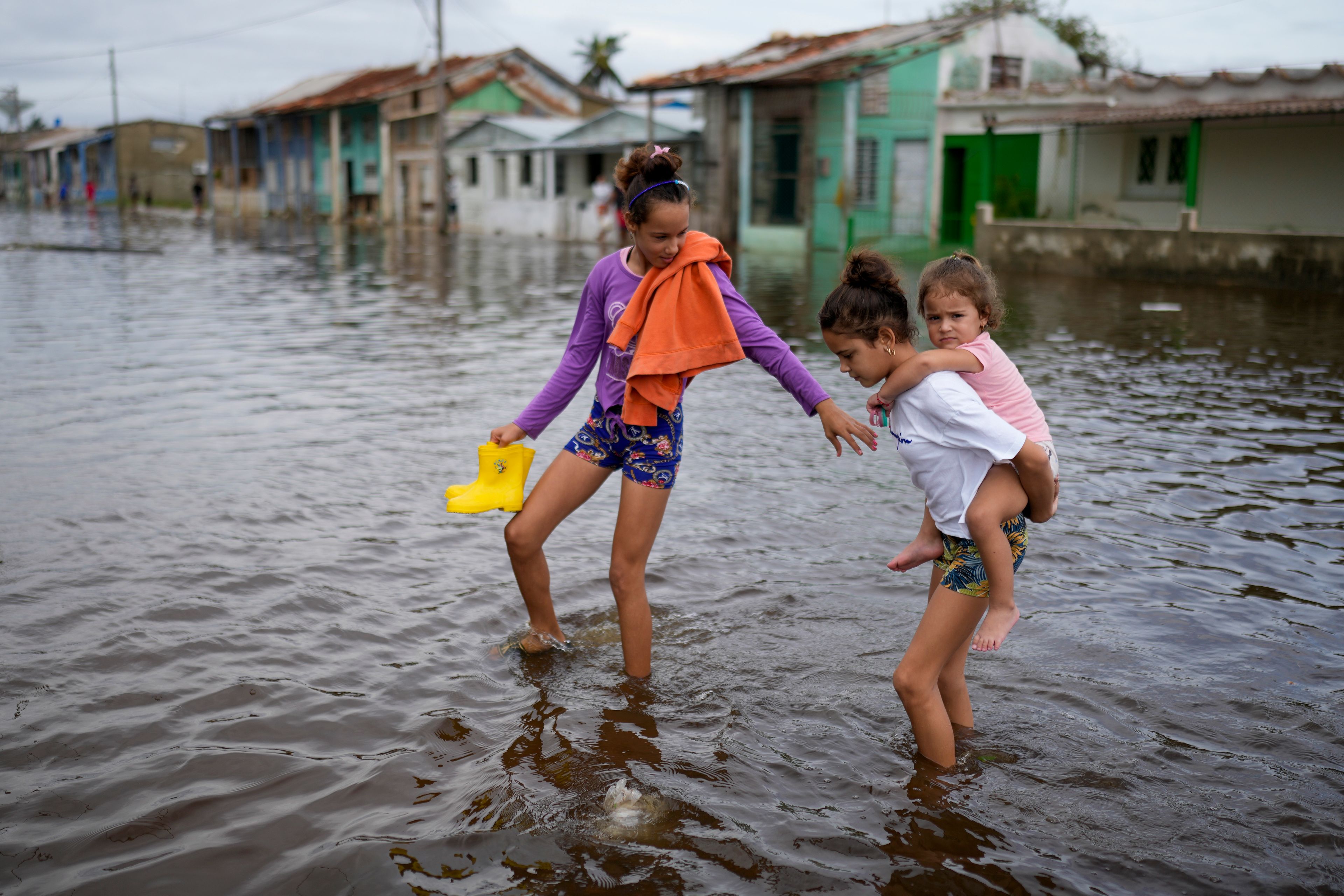 Children wade through a flooded street after the passing of Hurricane Rafael in Batabano, Cuba, Thursday, Nov. 7, 2024. (AP Photo/Ramon Espinosa)