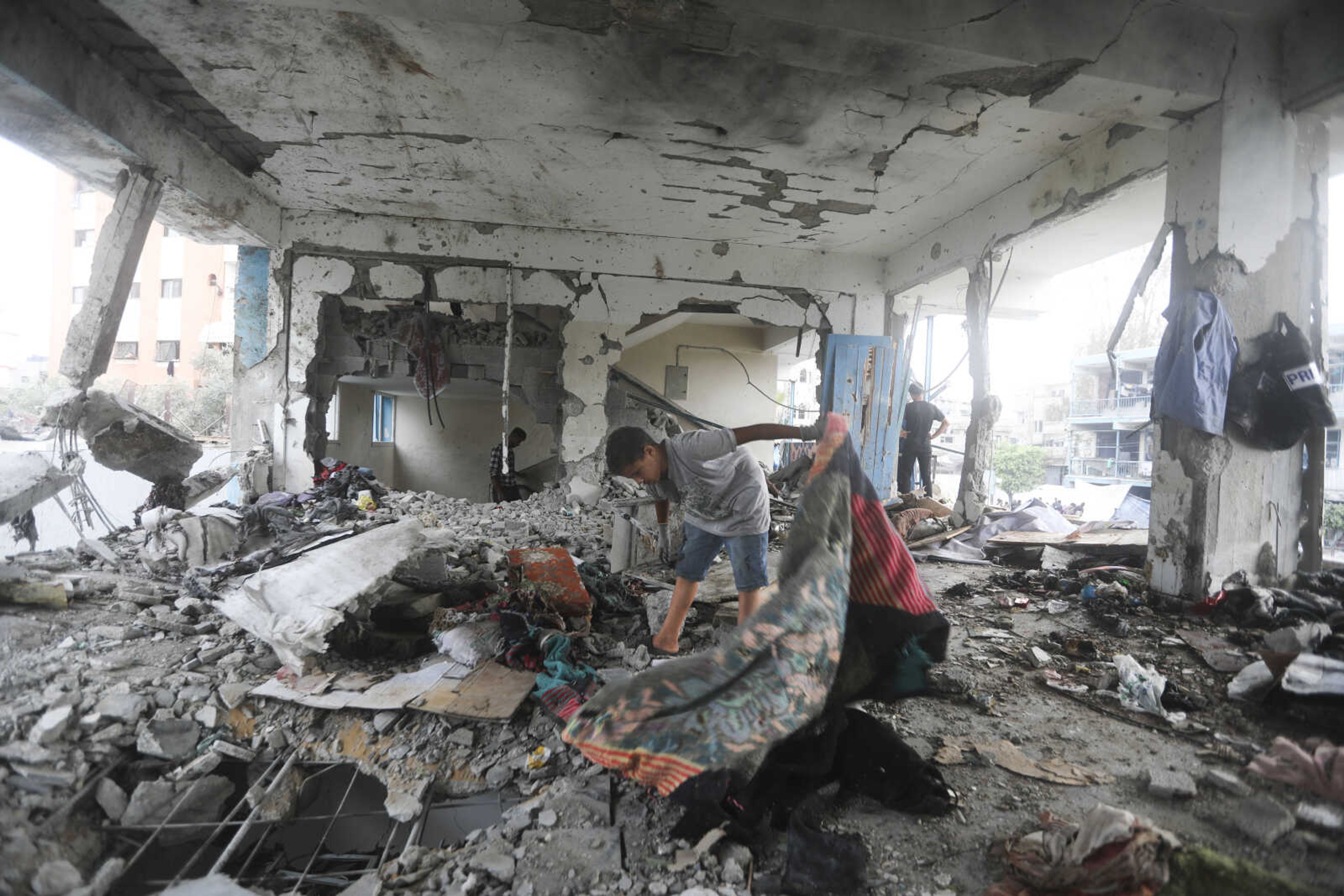 Palestinians look at the aftermath of the Israeli strike on a U.N.-run school that killed dozens of people in the Nusseirat refugee camp in the Gaza Strip, Thursday, June 6, 2024. 