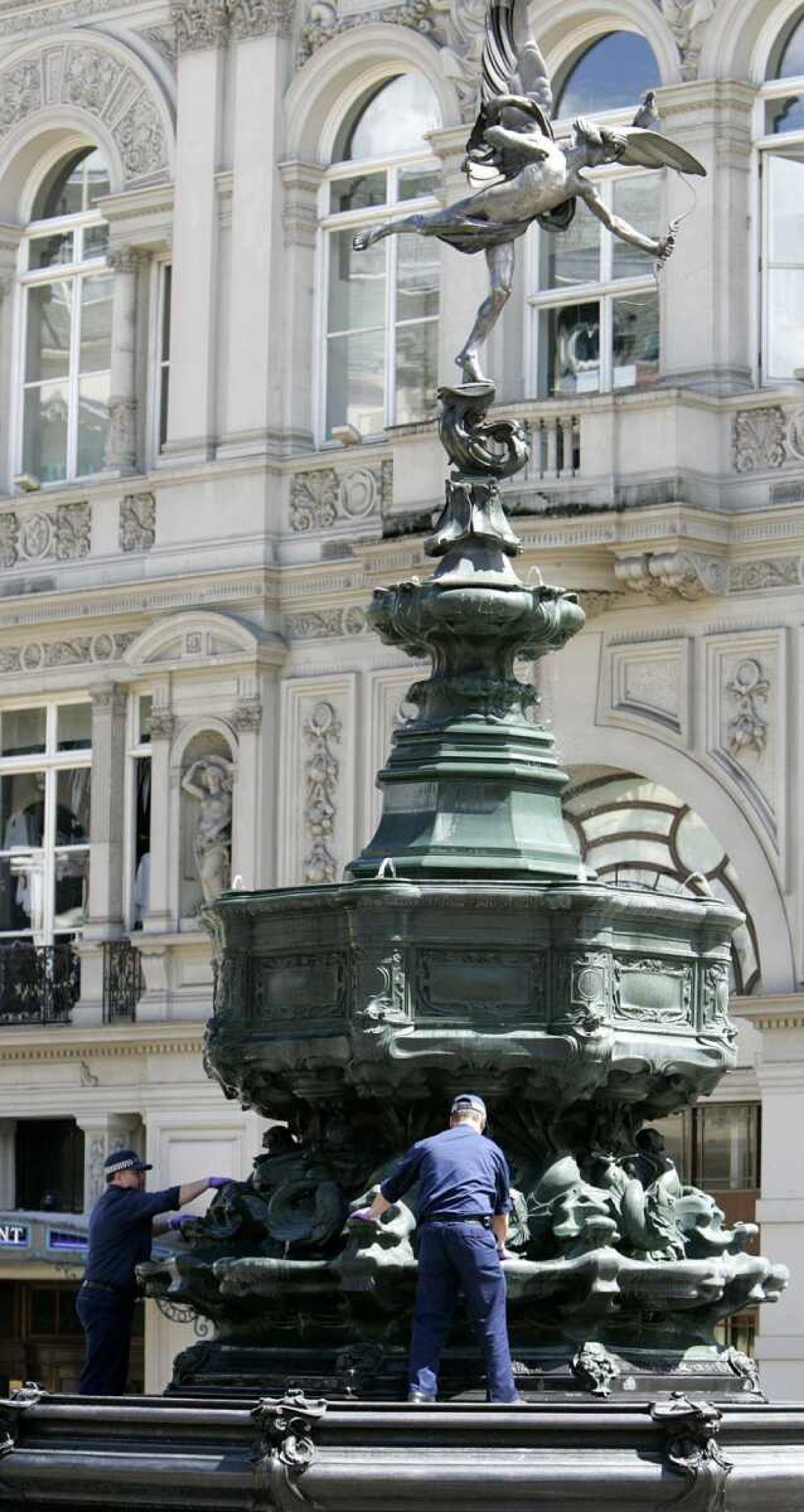 Police officers searched the fountain at the bottom of the Eros statue Friday in Piccadilly Circus, central London. Police there thwarted an apparent terror attack Friday, defusing an explosive car loaded with gasoline, gas canisters, nails and a detonator after an ambulance crew spotted smoke coming from the vehicle. The explosives were powerful enough to have caused "significant injury or loss of life" &#8212; possibly killing hundreds, British anti-terror police chief Peter Clarke said. (AKIRA SUEMORI ~ Associated Press)