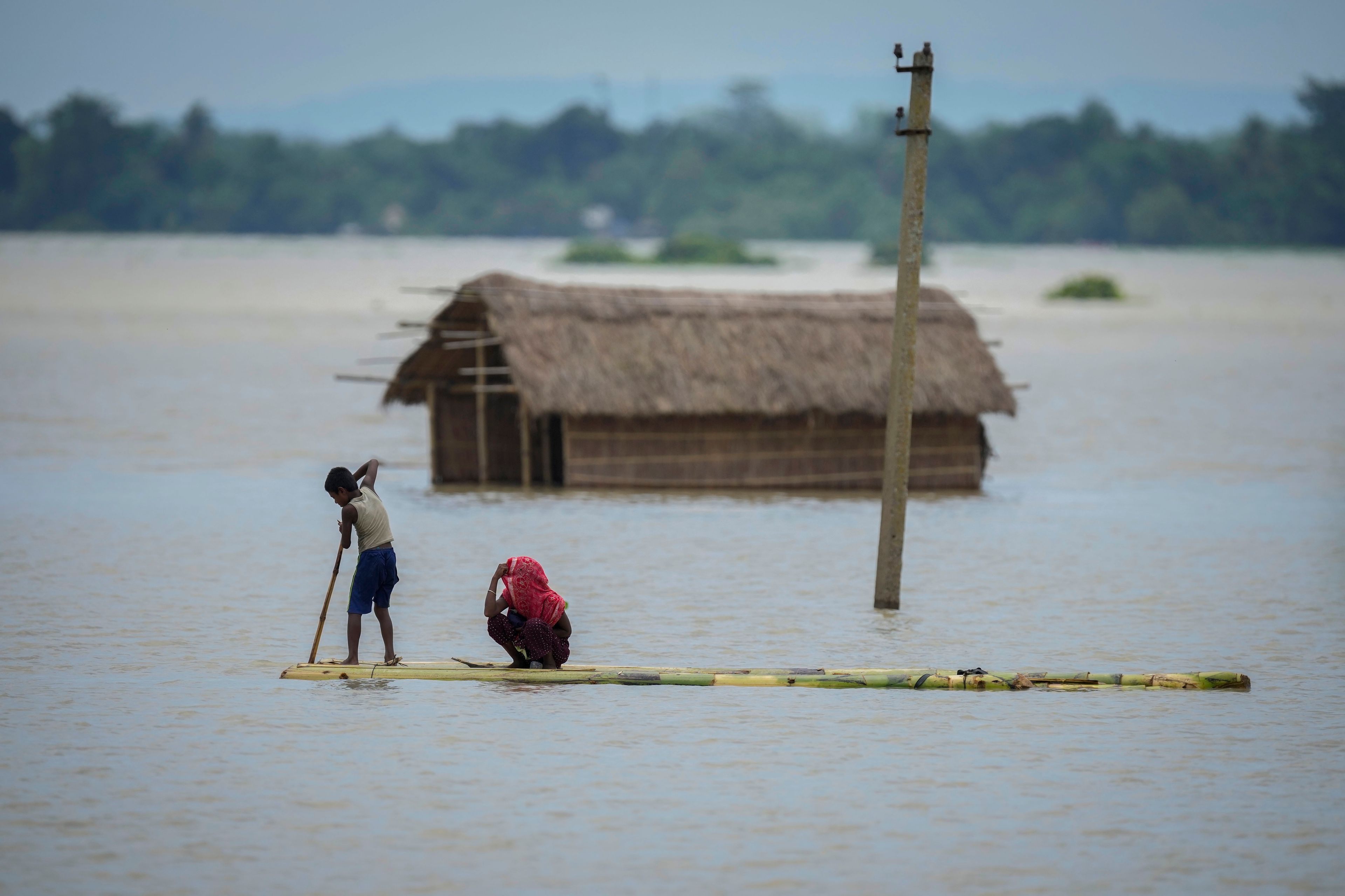 FILE - A young boy rows a makeshift banana raft to cross floodwaters in Morigaon district in the northeastern Indian state of Assam, India, July 3, 2024. (AP Photo/Anupam Nath, File)