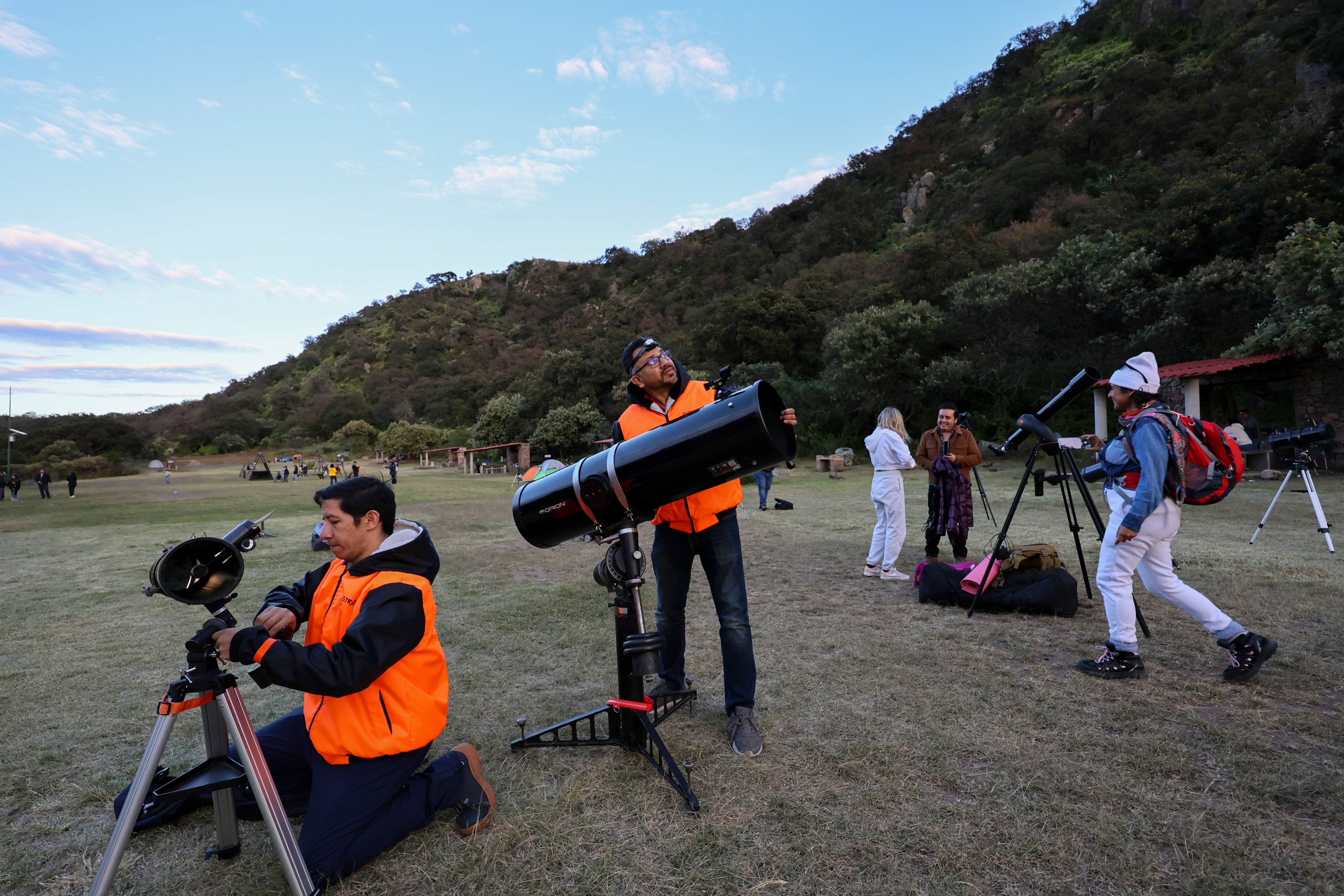 Frank Medina, left, and Juan Carlos Hernandez, center, arrange telescopes before attending a stargazing and comet-watching gathering at Joya-La Barreta ecological park in Queretaro, Mexico, Saturday, Oct. 19, 2024. (AP Photo/Ginnette Riquelme)