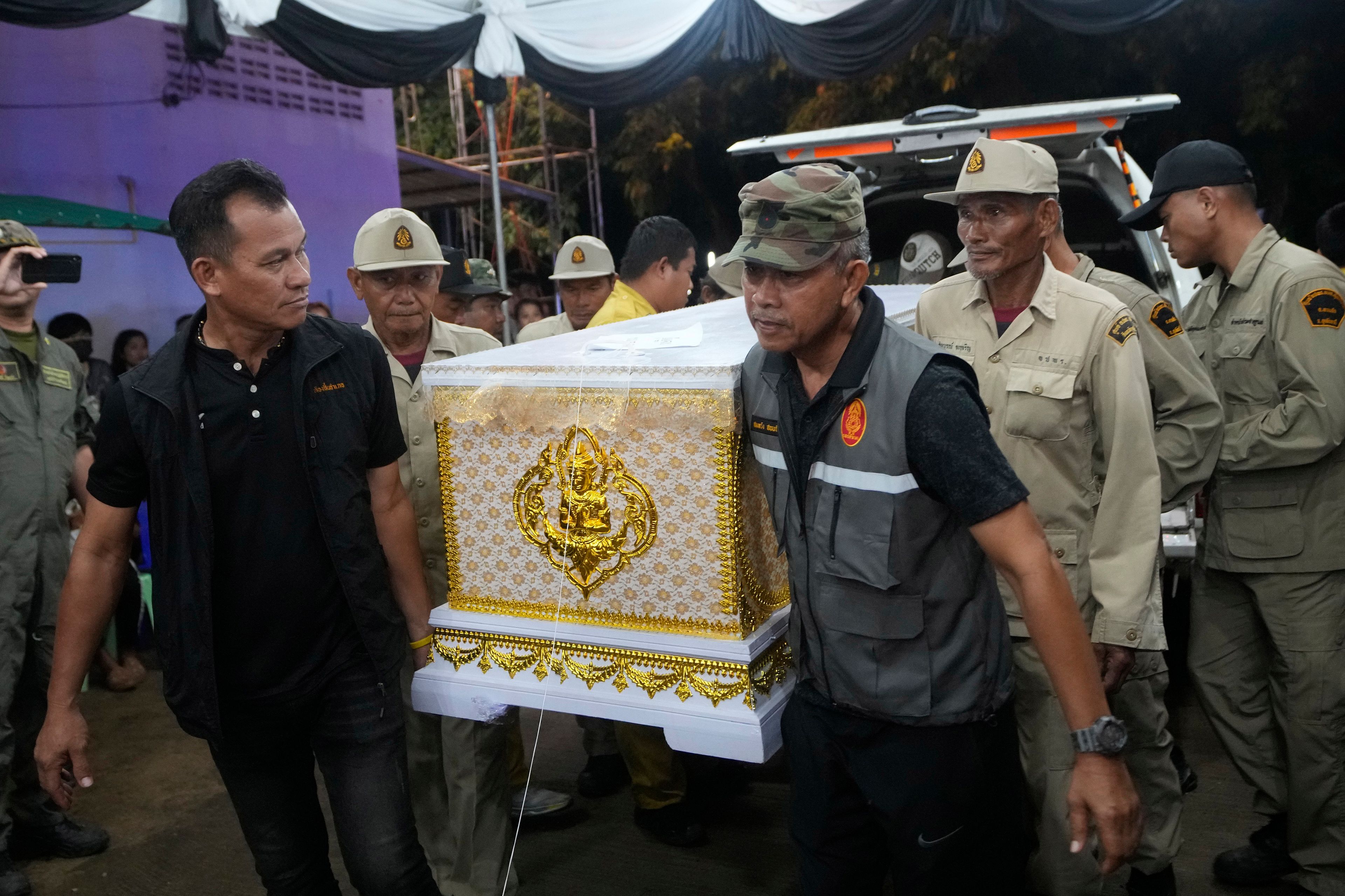 Officers carry a coffin of a bus fire victim as they arrive at Wat Khao Phraya Sangkharam School Lan Sak, Uthai Thani province, Thailand, Thursday, Oct. 3, 2024. (AP Photo/Sakchai Lalit)