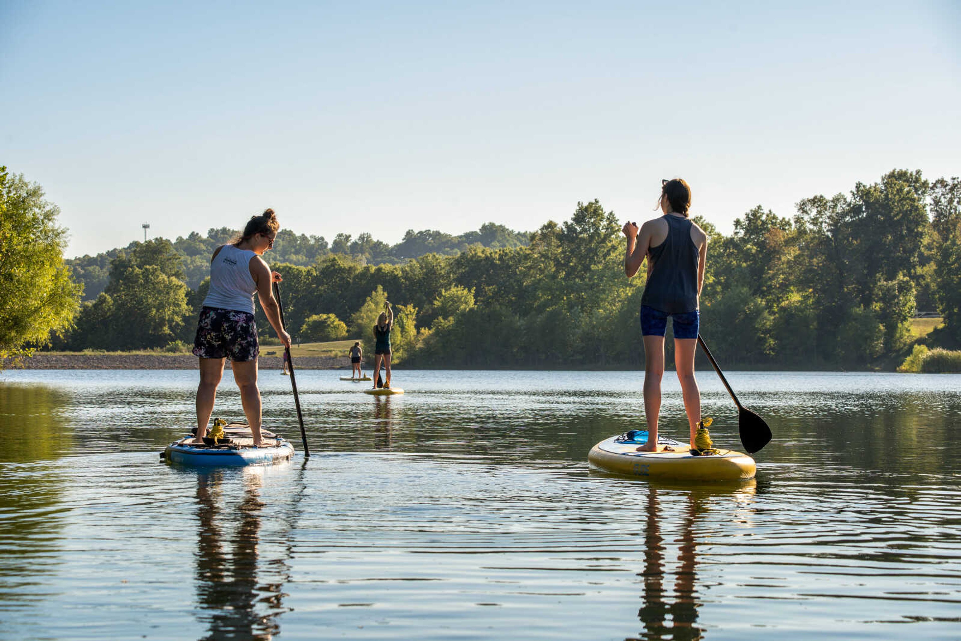 Jasmine Jones and other students paddle out to the stand up paddleboard (SUP) yoga class location. The classes occur at Lake Boutin at Trail of Tears State Park.