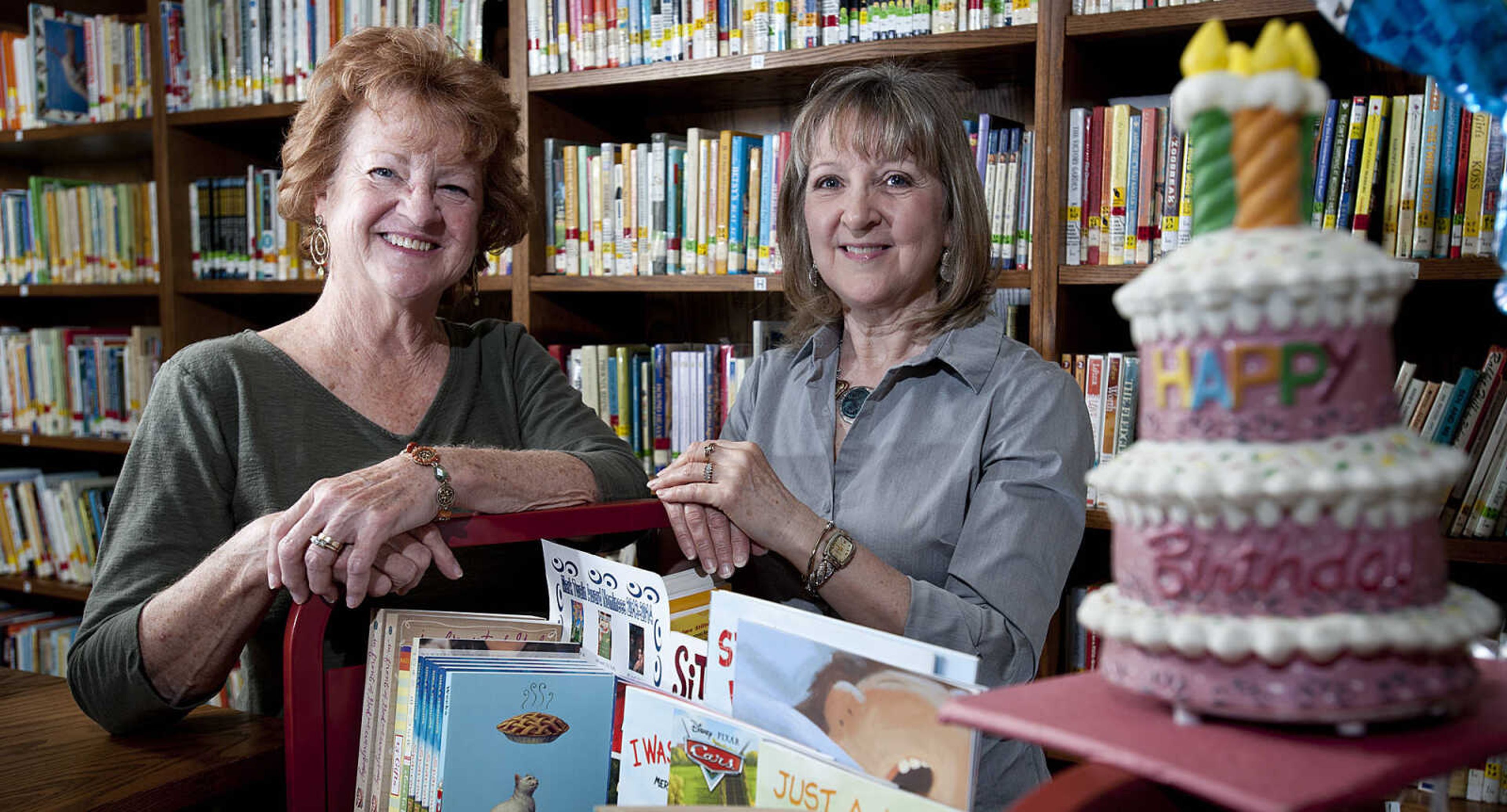 Karen Gibbar, left, and Donna Sanders pose with the Birthday Cart at Blanchard Elementary School in Cape Girardeau. The two retired teachers have students pick out a free book from the cart on their birthdays. (Adam Vogler)