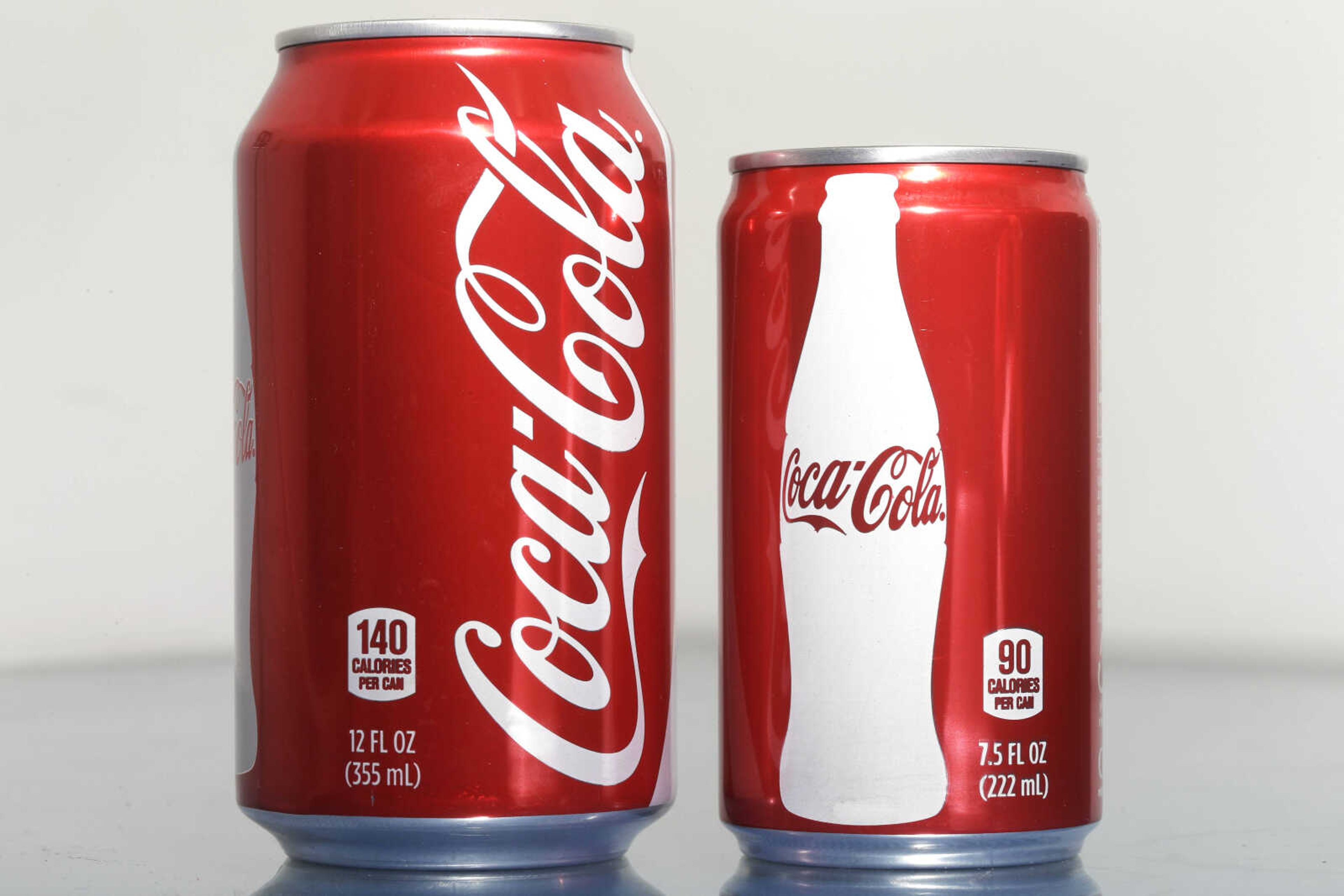 A 7.5-ounce can of Coca-cola, right, is posed next to a 12-ounce can for comparison Jan. 12 in Philadelphia. (Matt Rourke ~ Associated Press)