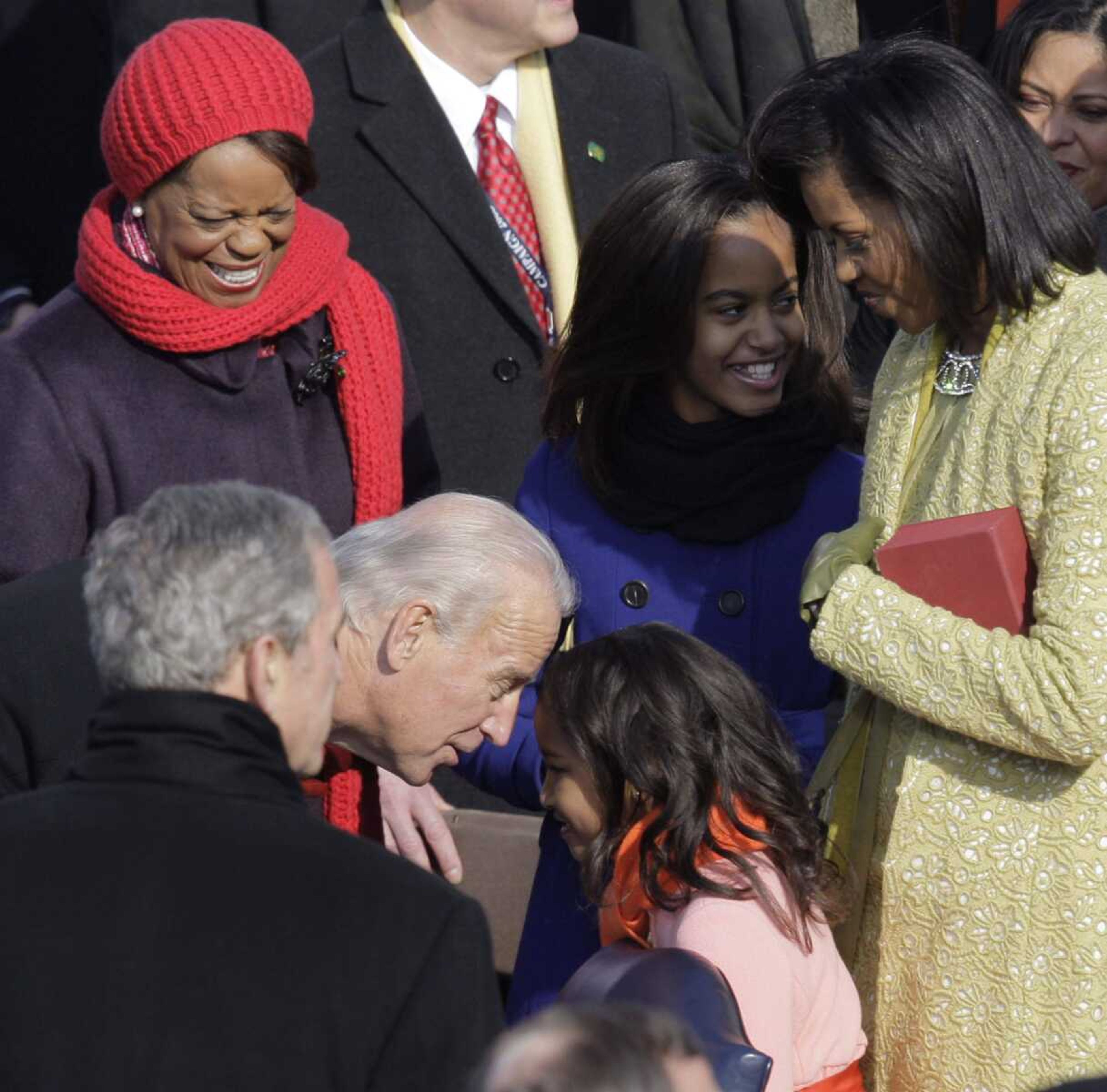 Vice President-elect Joe Biden greets Sasha Obama as Michelle Obama talks to her daughter Malia before the inauguration ceremony at the U.S. Capitol in Washington, Tuesday, Jan. 20, 2009. (AP Photo/Jae C. Hong)