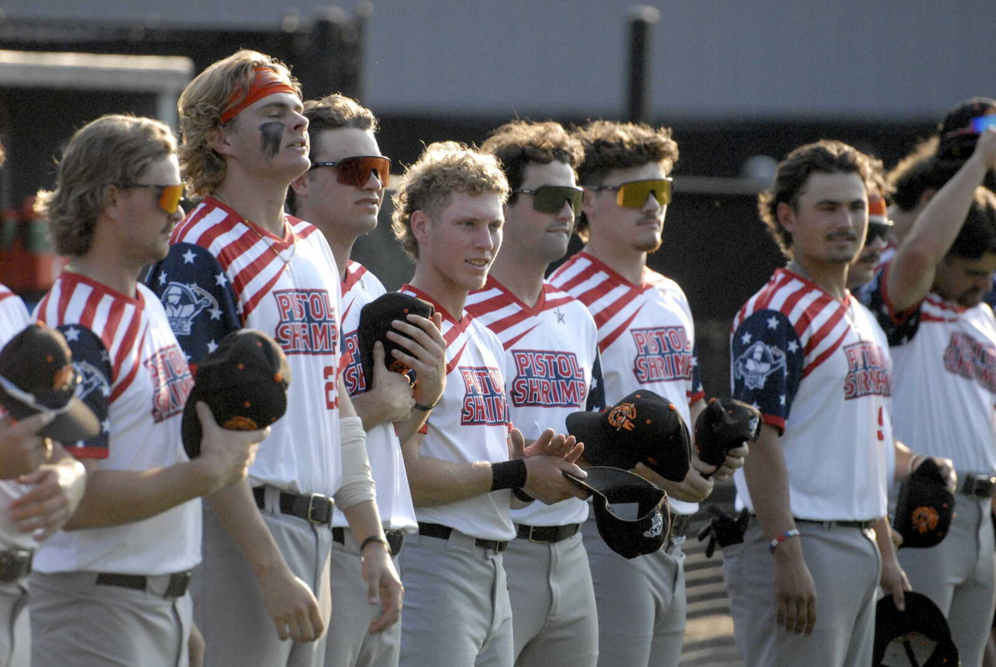 Former Southeast Missouri State baseball player, Chance Resetich (fourth from left), now playing for the Illinois Valley Pistol Shrimp, stands for the National Anthem prior to Saturday's game with the Cape Catfish at Capaha Field. 