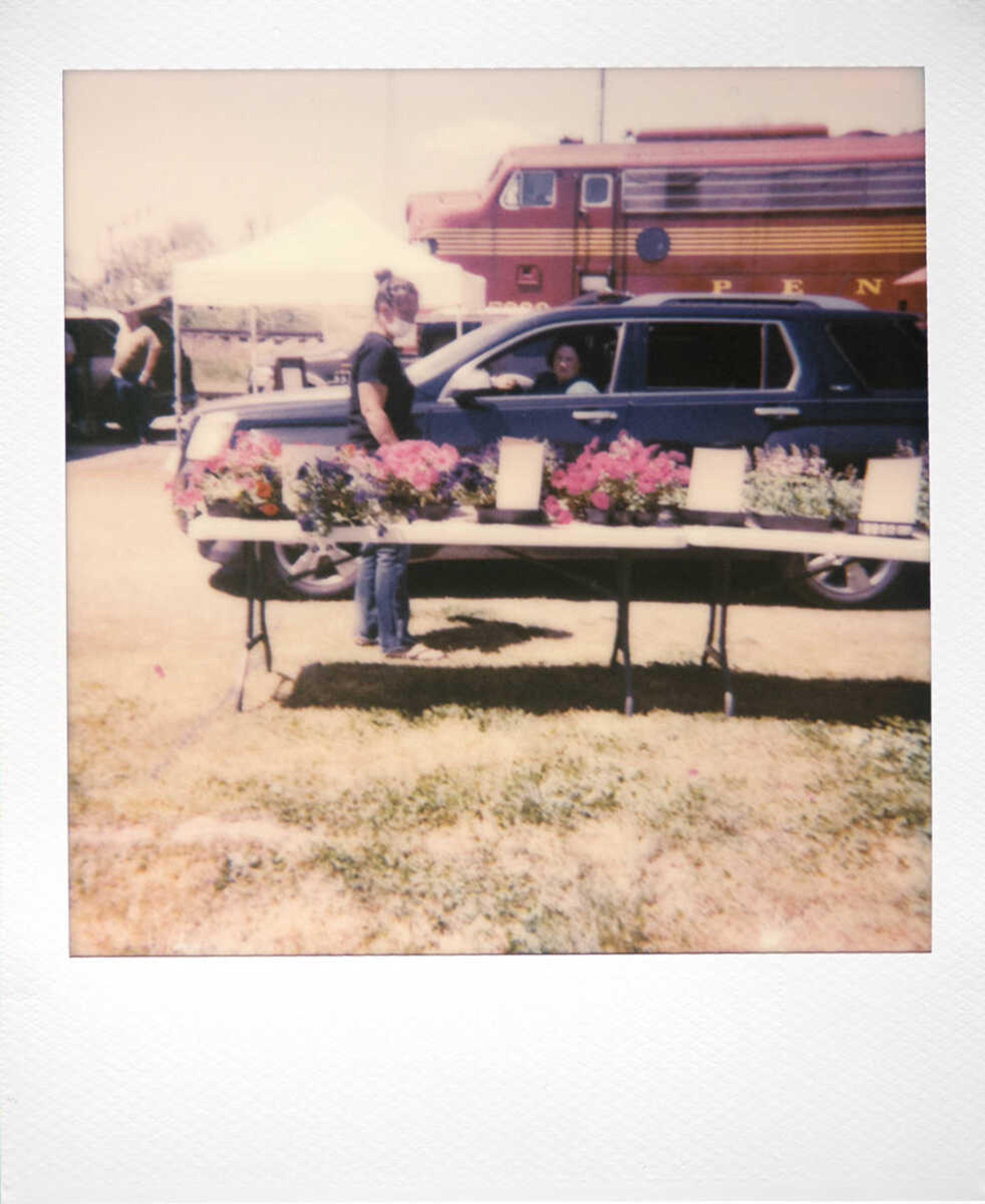 Tracy Foster of Sikeston, Missouri, shops from her vehicle while assisted by April (who declined to provide her last name) of Cobden, Illinois, during Jackson's drive-through farmers market Tuesday, April 21, 2020, at the St. Louis Iron Mountain and Southern Railway depot in Jackson.&nbsp; Market customers were able to do their shopping without leaving their vehicles.