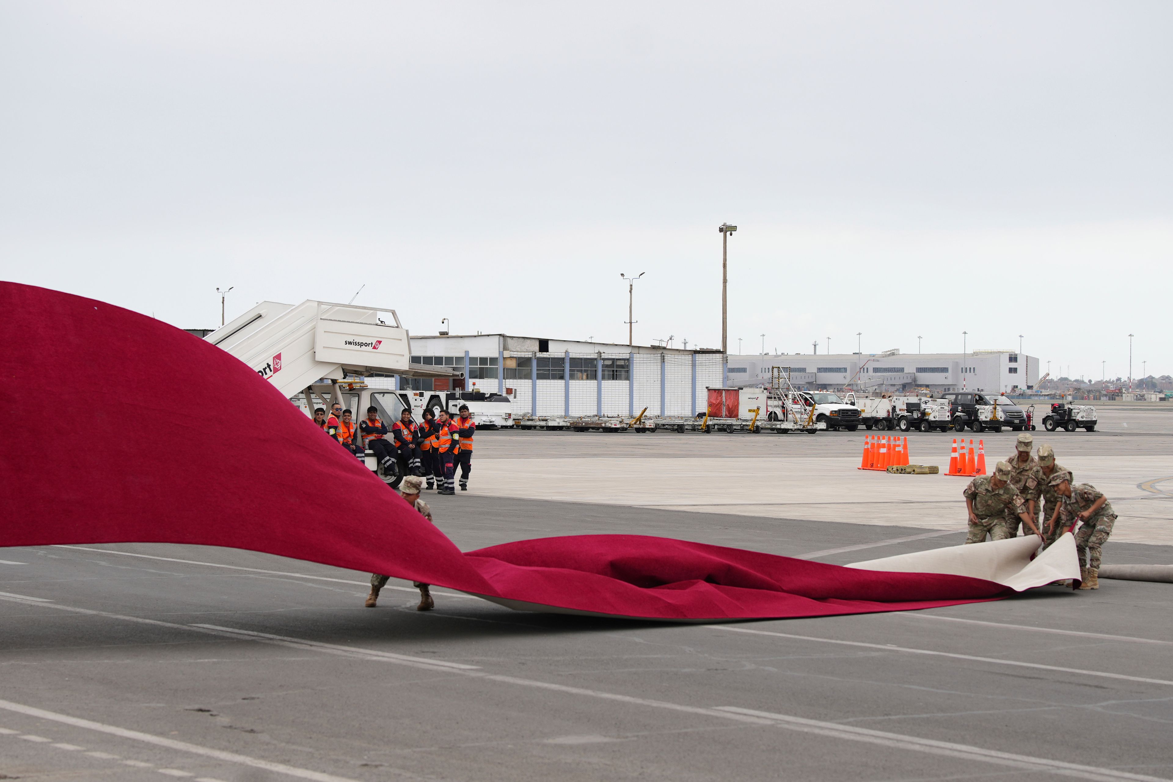 Air Force members fix the red carpet before the arrival of Vietnam's President Luong Cuong in Lima, Peru, for the Asia-Pacific Economic Cooperation (APEC) summit, Tuesday, Nov. 12, 2024. (AP Photo/Guadalupe Pardo)