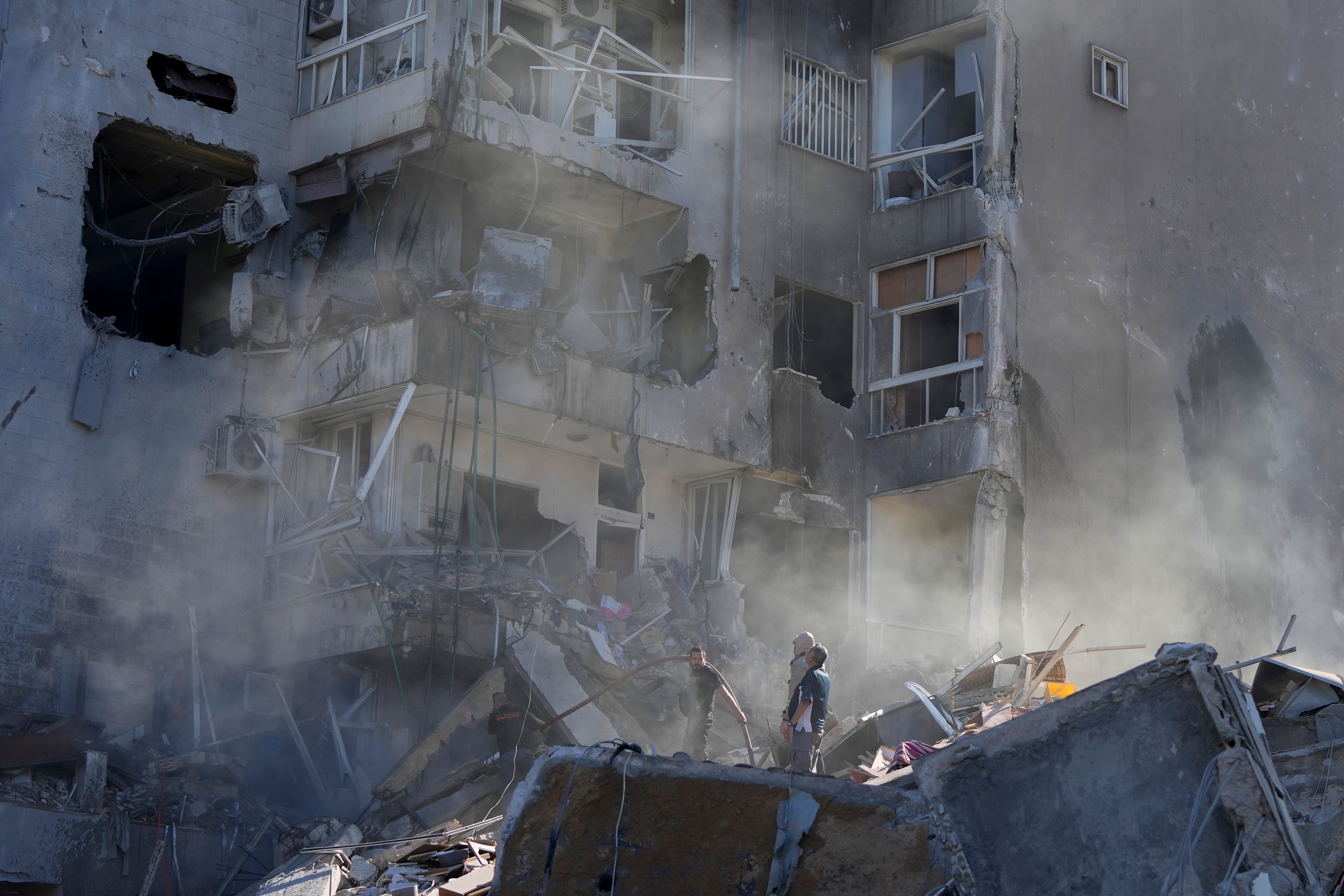 Residents check the site of an Israeli airstrike in Tayouneh, Beirut, Lebanon, Friday, Nov. 15, 2024. (AP Photo/Hassan Ammar)