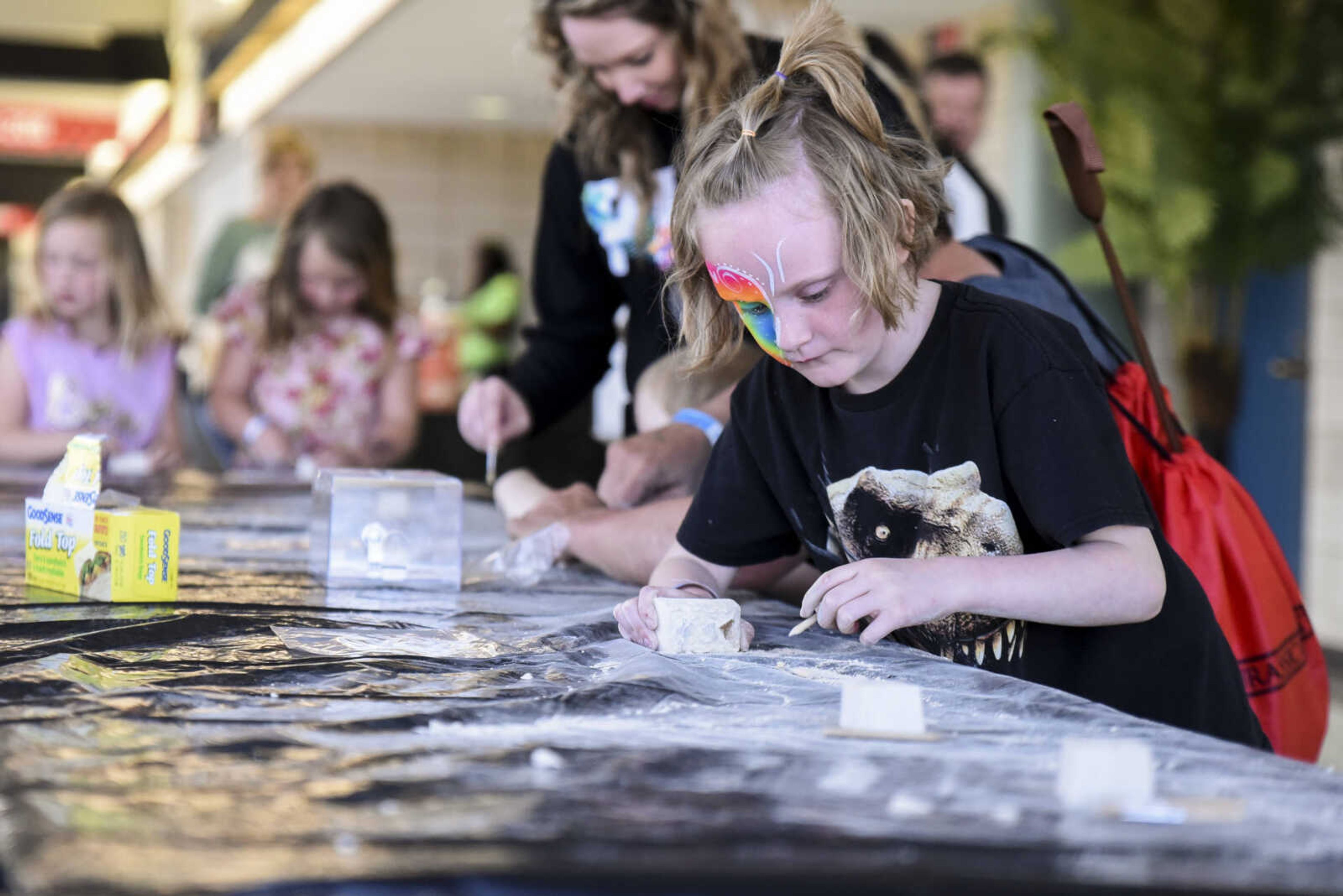 Harlow Ebers, 6, participates in the fossil excavation at Jurassic Quest Friday, April 27, 2018, at the Show Me Center in Cape Girardeau.