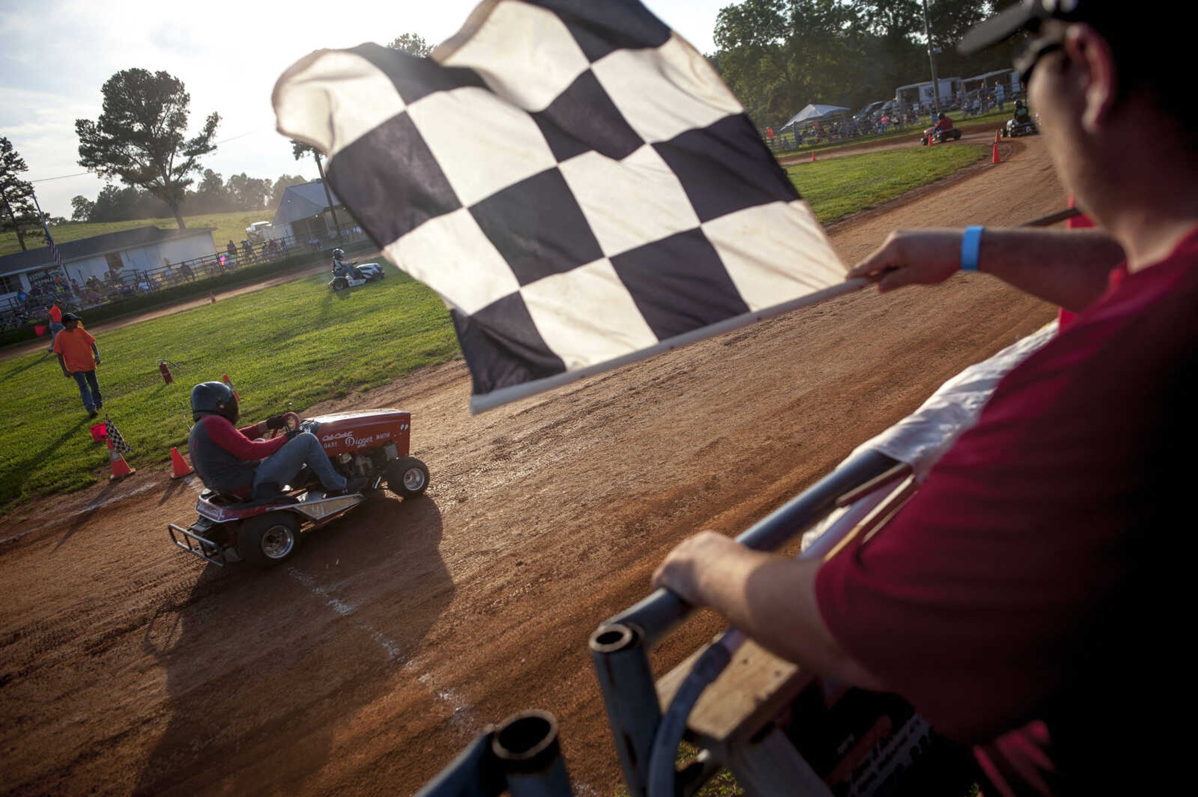 A racer runs his lawnmower across the finish line during a heat race on Saturday, Aug. 10, 2019, at the Patton Saddle Club in Patton, Missouri. Many racers in the top tier swear that with about $10,000 in aftermarket modifications and a competent driver, a lawnmower can do highway speeds on the track. Wayne Goodwin, septuagenarian member of the Old Farts Racing Team, said that even though the only prize is a $7 plaque, racers pour money and time into their vehicles and risk serious bodily harm to win. "Because there's just nothin' like it," Goodwin said. "I'll never quit."