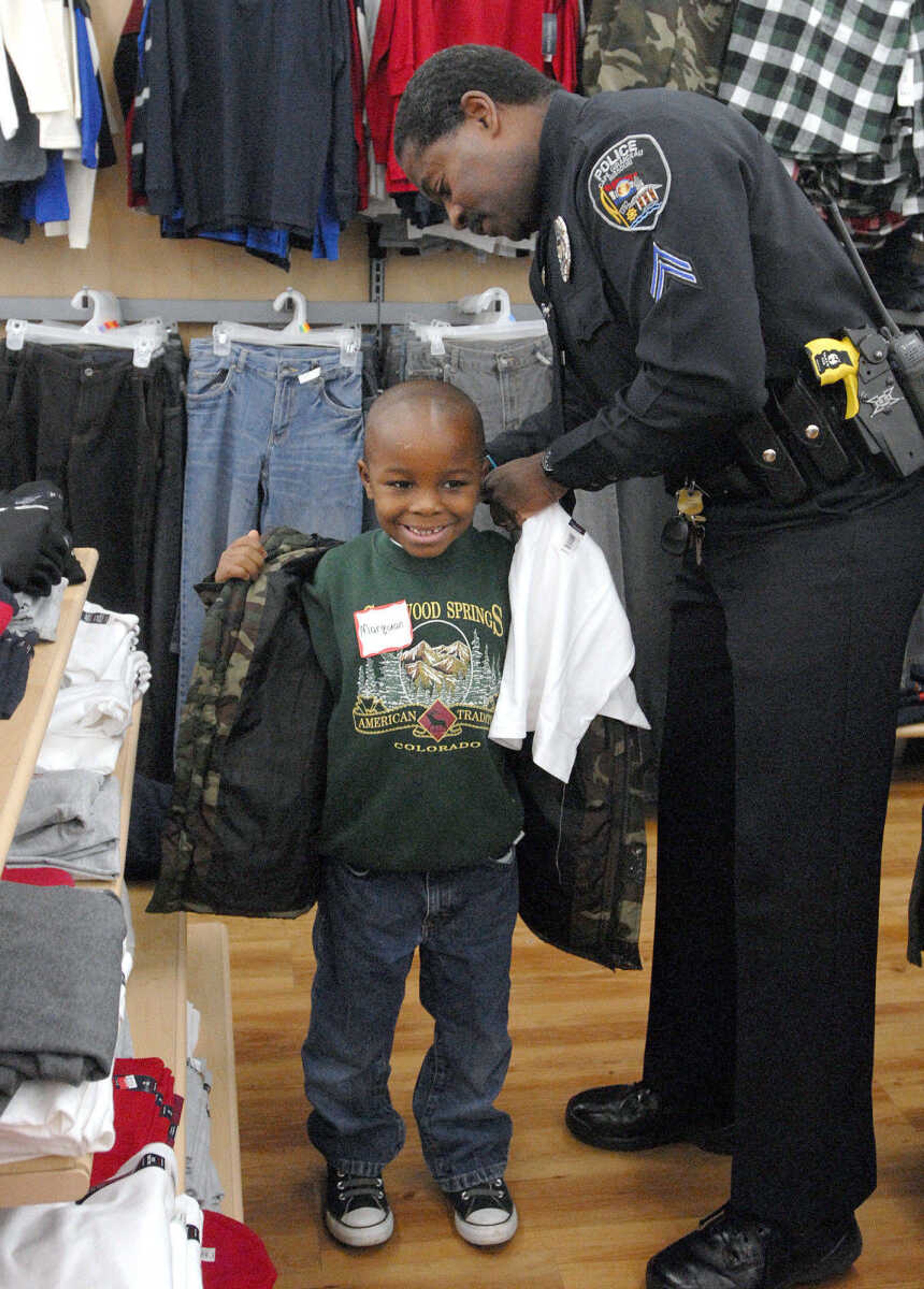 LAURA SIMON ~ lsimon@semissourian.com
Officer Ike Hammonds of the Cape Girardeau Police Department checks the size of Marquan Long's shirt as they shop for clothes Tuesday morning, Dec. 6, 2011 at Walmart in Cape Girardeau. Long was one of around 100 children that got to Shop with a Hero Tuesday morning. This is the 20th year that Walmart has held the Christmas shopping event that allows children to shop with donated money for toys, clothing or any item of their choice within the amount raised. This year each child received around $85 to spend with the help of local police officers, firefighters and first responders.