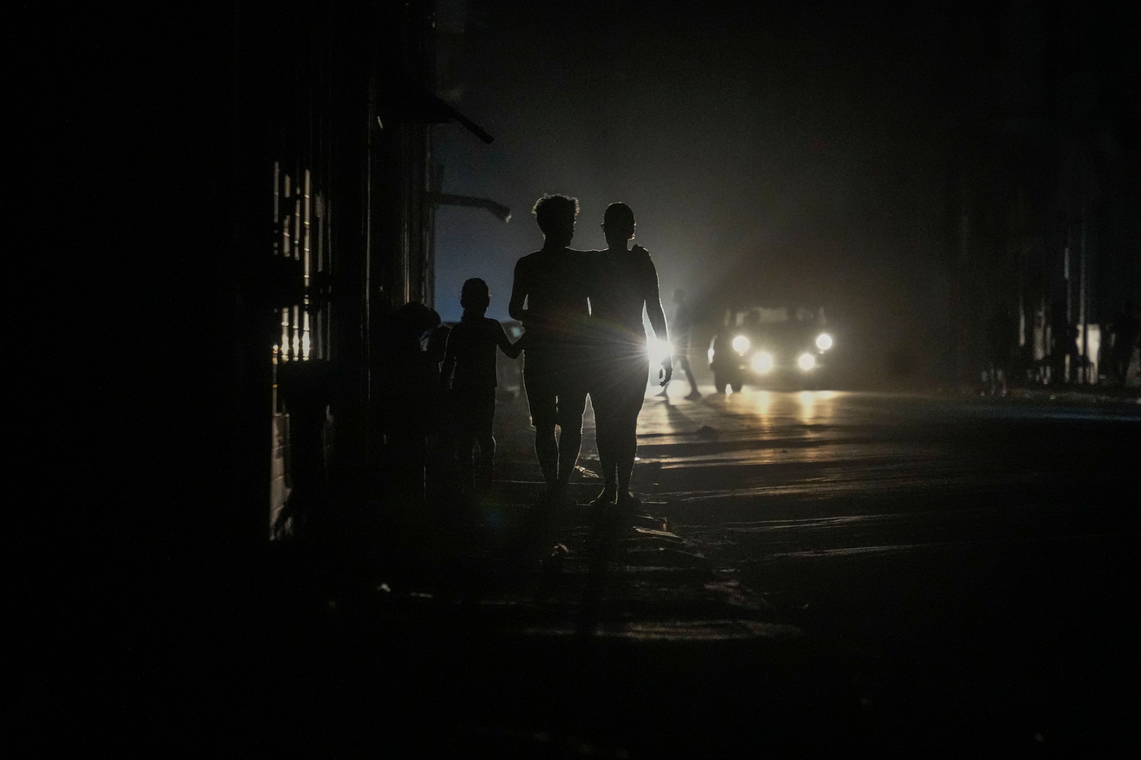 Residents walk on a street during a blackout following the failure of a major power plant in Havana, Cuba, Sunday, Oct. 20, 2024. (AP Photo/Ramon Espinosa)