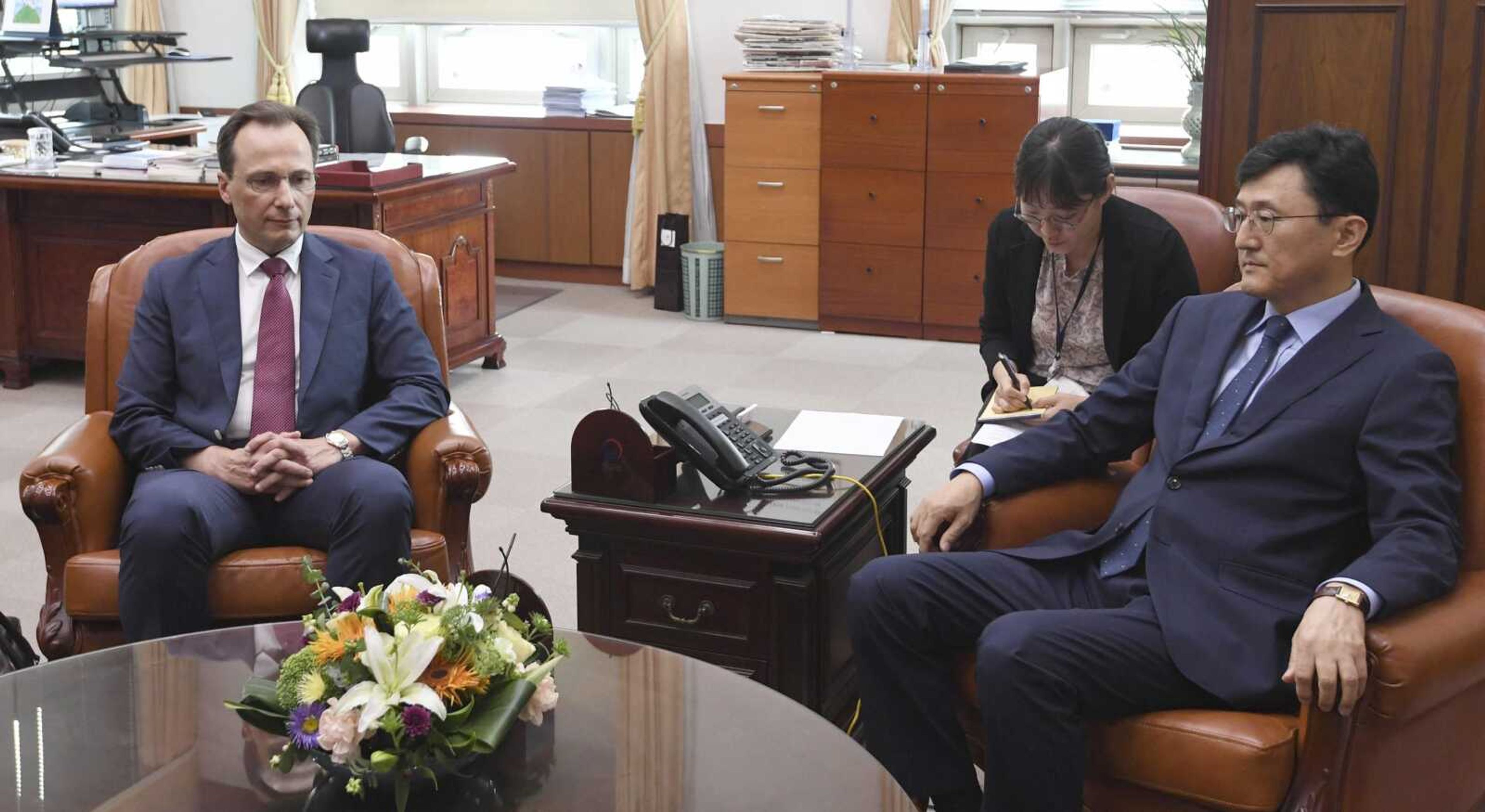 Acting Russian Ambassador to South Korea Maxim Volkov, left, and South Korean Deputy Minister for Political Affairs Yoon Soon-gu take their seats before their meeting at the Foreign ministry in Seoul, South Korea, Tuesday, July 23, 2019. Yoon on Tuesday summoned Volkov to protest the countries  military jets entering South Korea's airspace. (Kim Sung-do/Yonhap via AP)