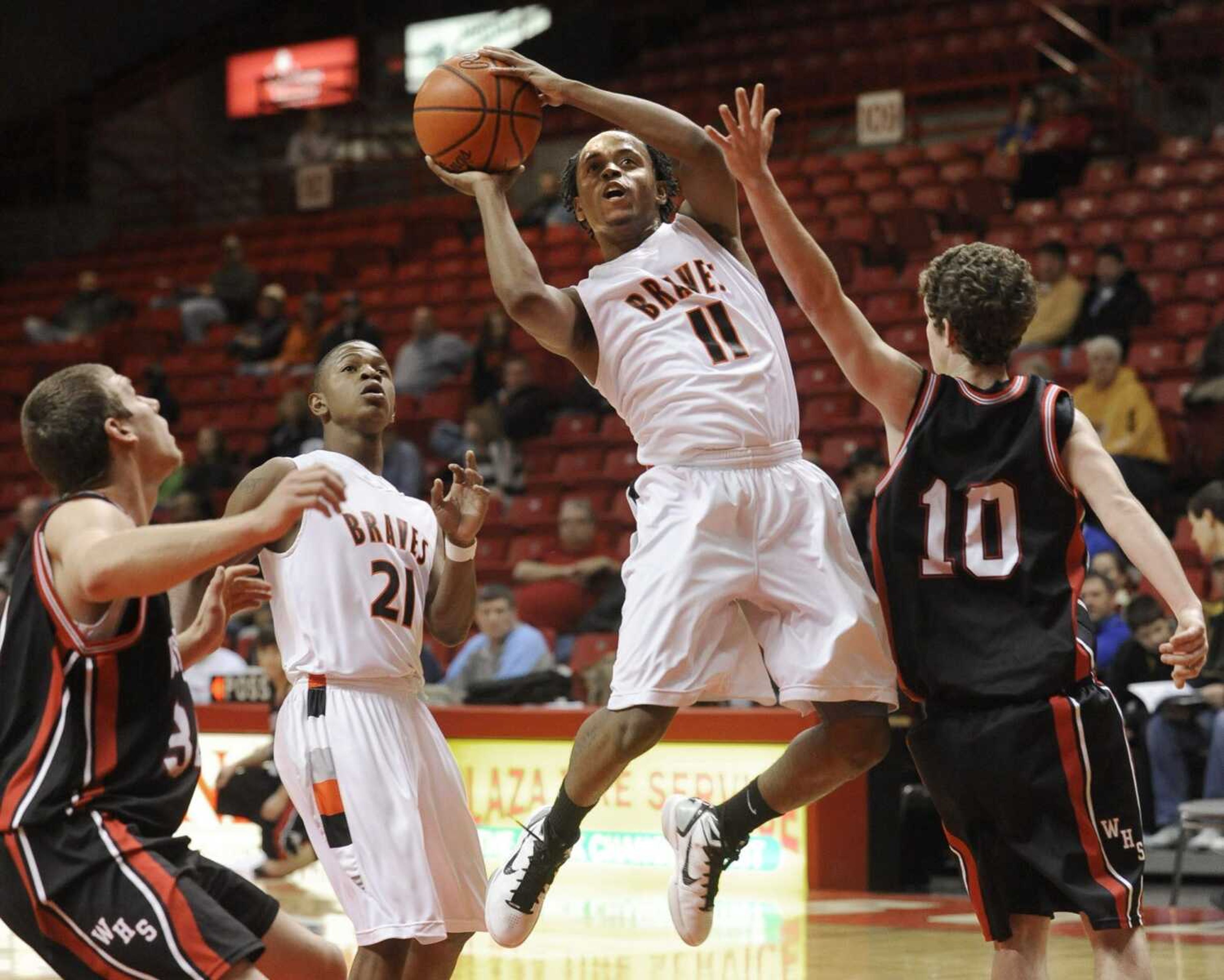 Scott County Central's Stewart Johnson shoots against Woodland's Nick Deck (10) and Neil Johnson, left, during the first quarter Monday, Dec. 27, 2010 in the Southeast Missourian Christmas Tournament at the Show Me Center. (Fred Lynch)