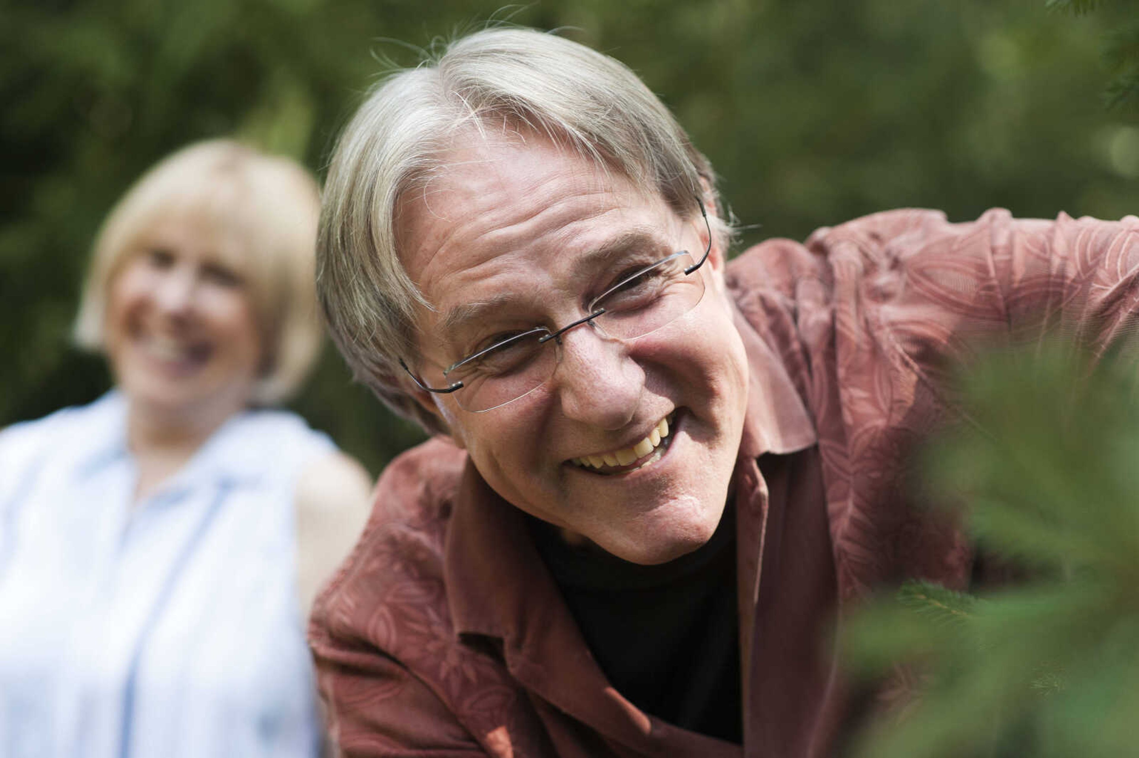 Dr. Russ Felker examines one of the Christmas trees he planted in his yard in Cape Girardeau while his wife, Susie Felker, looks on.