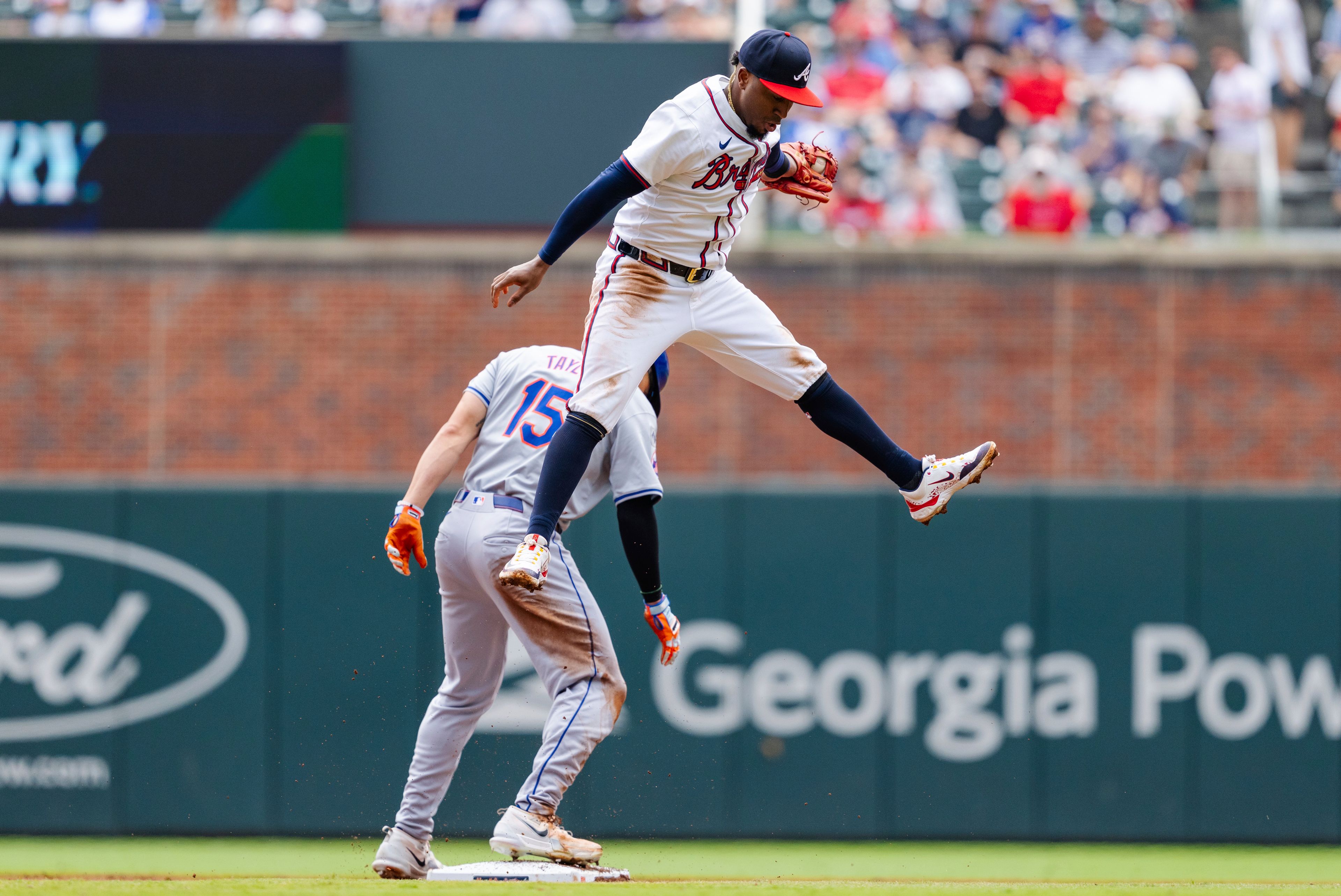 New York Mets' Tyrone Taylor steal second base before Atlanta Braves second baseman Ozzie Albies, top, can tag him in the third inning of a baseball game, Monday, Sept. 30, 2024, in Atlanta. (AP Photo/Jason Allen)