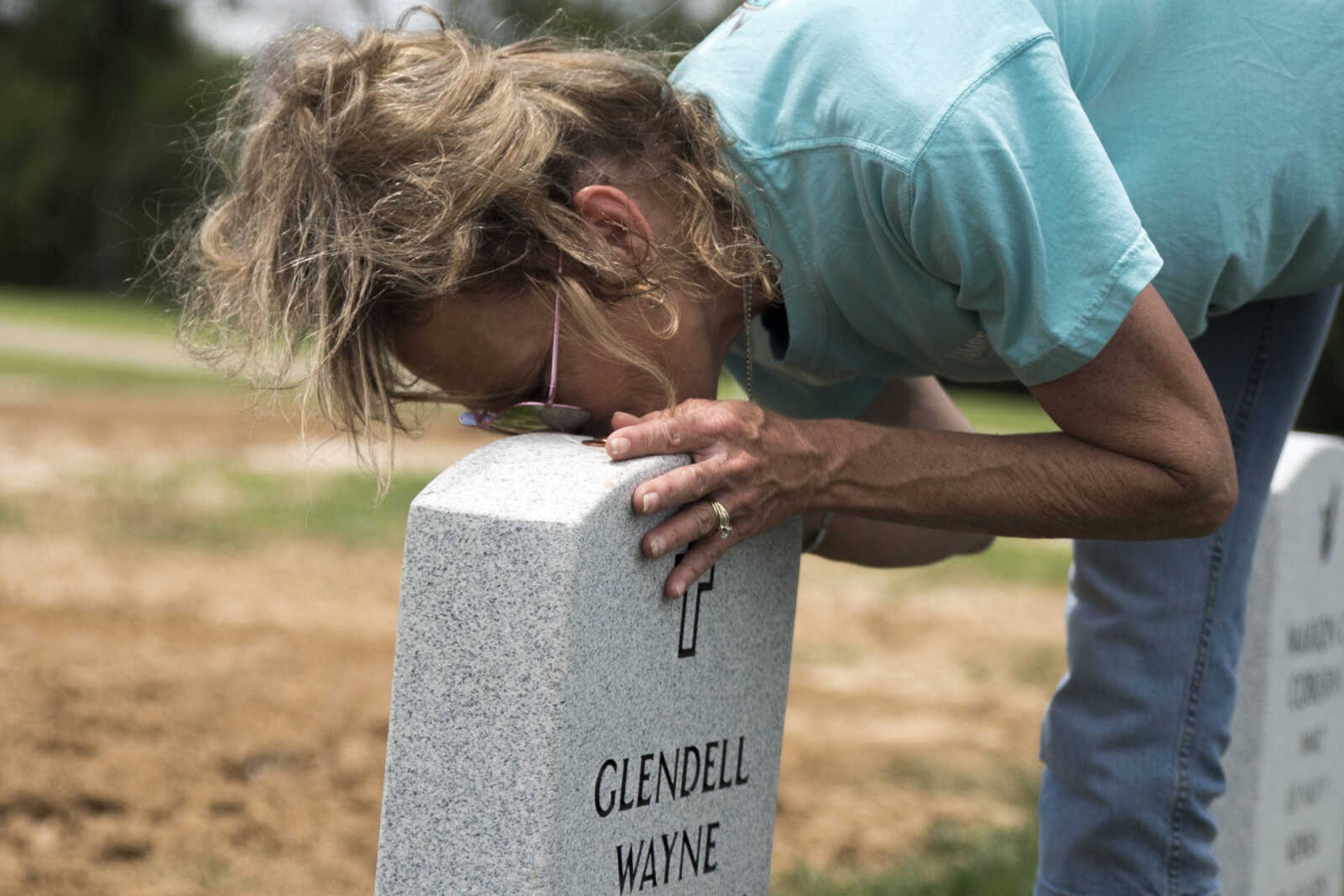 Pamela Woodrow, of Advance, kisses her husband's headstone at the Missouri Veterans Cemetery at Bloomfield on Thursday, May 23, 2019, in Bloomfield, Missouri. "I always have to kiss him before I leave," Pamela said.