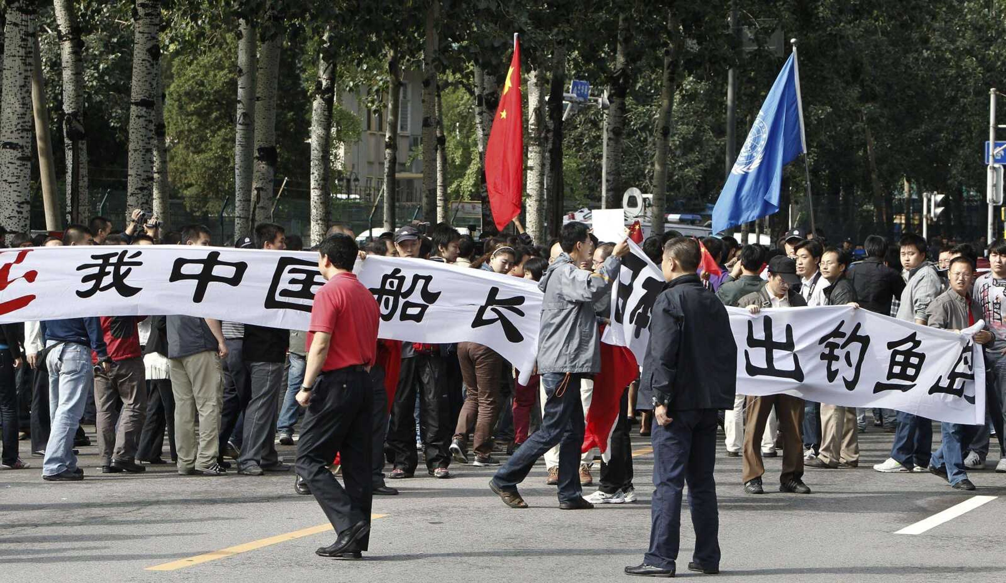 Protesters carry a banner that reads "Release our China ship's captain, Get out of Diaoyu Island" as they hold an anti-Japan protest Saturday outside the Japanese Embassy in Beijing. (Andy Wong ~ Associated Press)