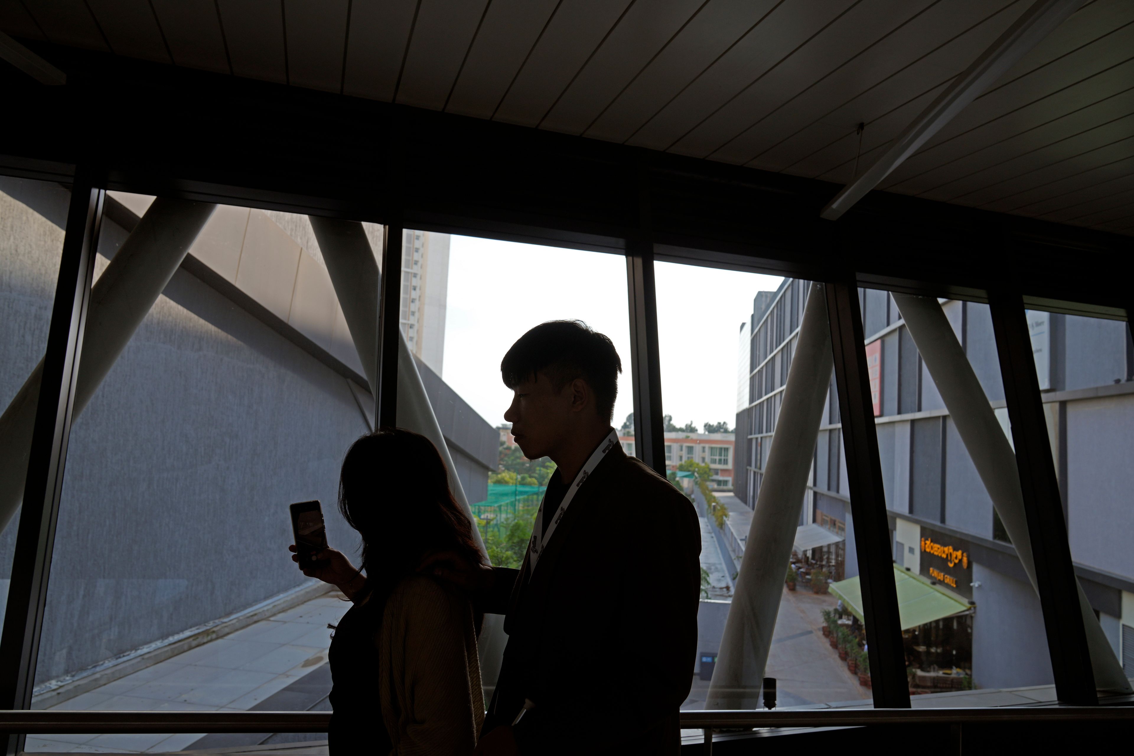 Imlibenla Jamir, 30, left, guides her brother Takosangba Jamir, 27, a blind pianist, through a passageway towards an auditorium during the two-day Brillante Piano Festival in Bengaluru, India, Sunday, Sept. 29, 2024. (AP Photo/Aijaz Rahi)