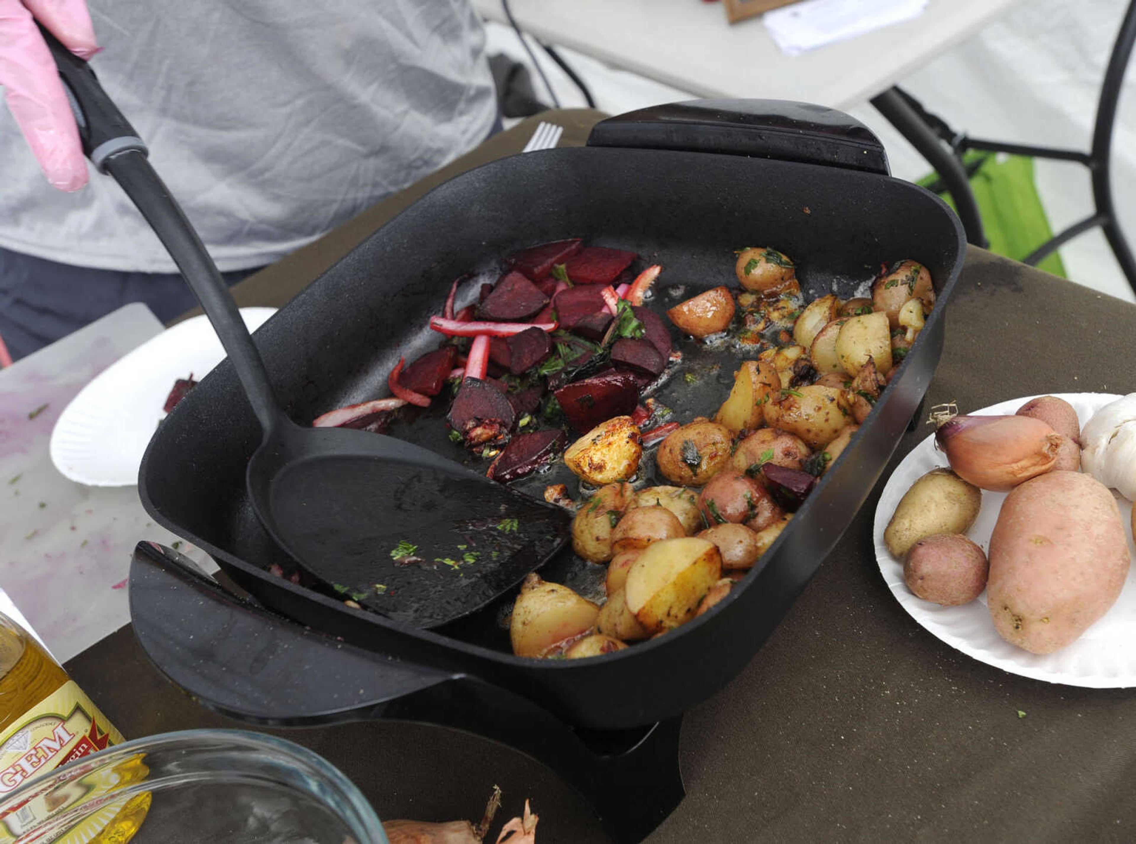 Charity Worley prepares sauteed beets and greens in a food demonstration at the Cape Riverfront Market.