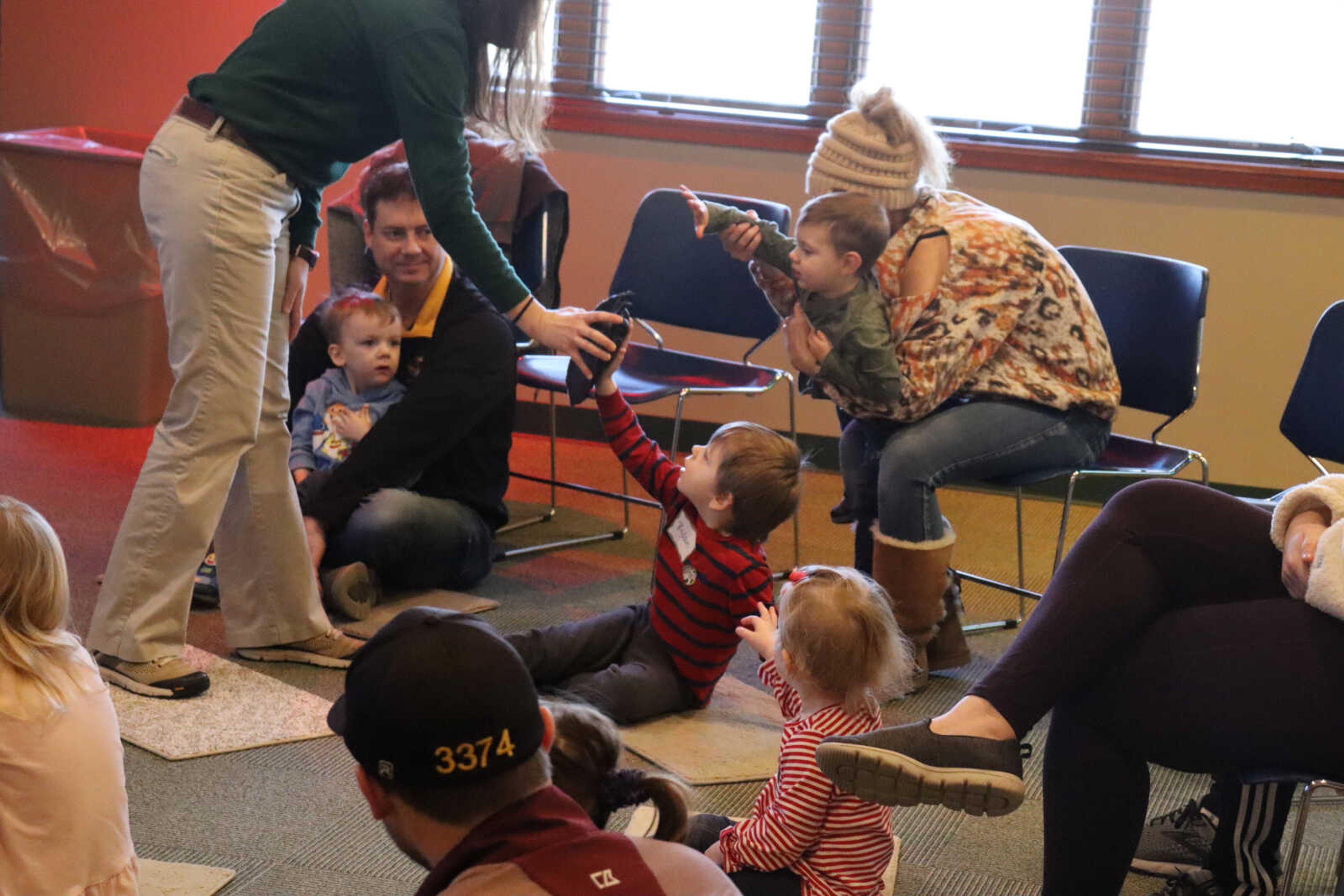 A kid reaches out to touch a plastic replica of a bear paw.