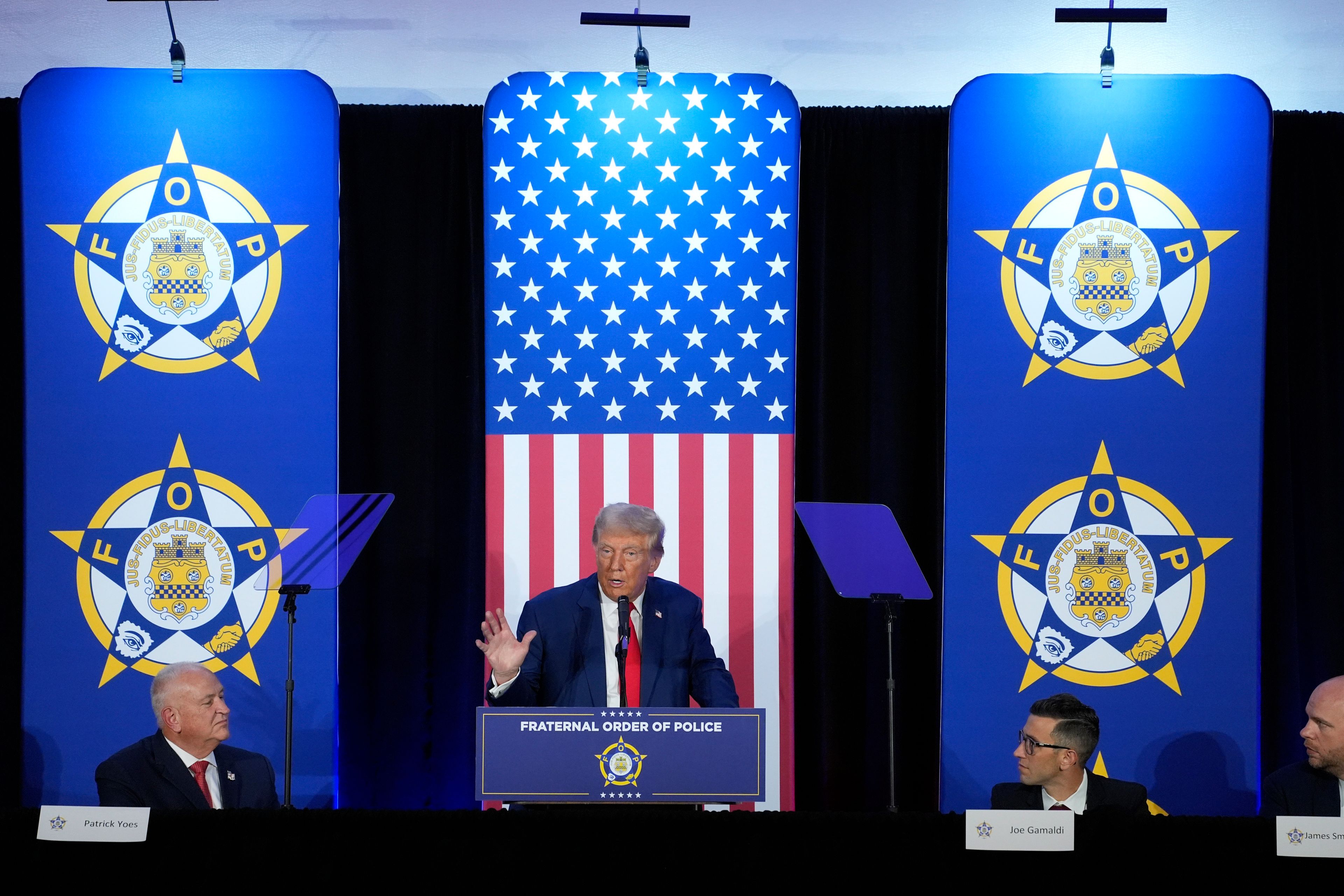 Republican presidential nominee former President Donald Trump speaks to the National Fraternal Order of Police fall meeting, Friday, Sept. 6, 2024, in Charlotte, N.C., as FOP president Patrick Yoes, left, and FOP vice president Joe Gamaldi listen. (AP Photo/Evan Vucci)