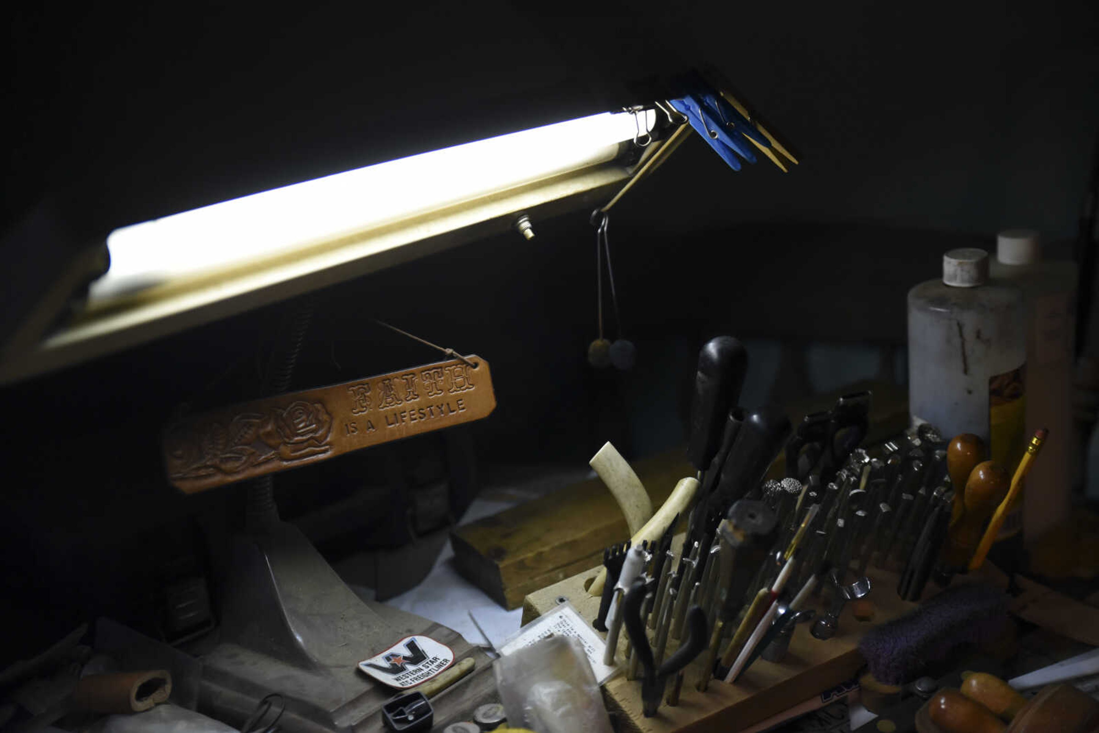 John Hedge's leather-making tools sit on his desk under a lamp in his home on Tuesday, March 27, 2018, in Advance.