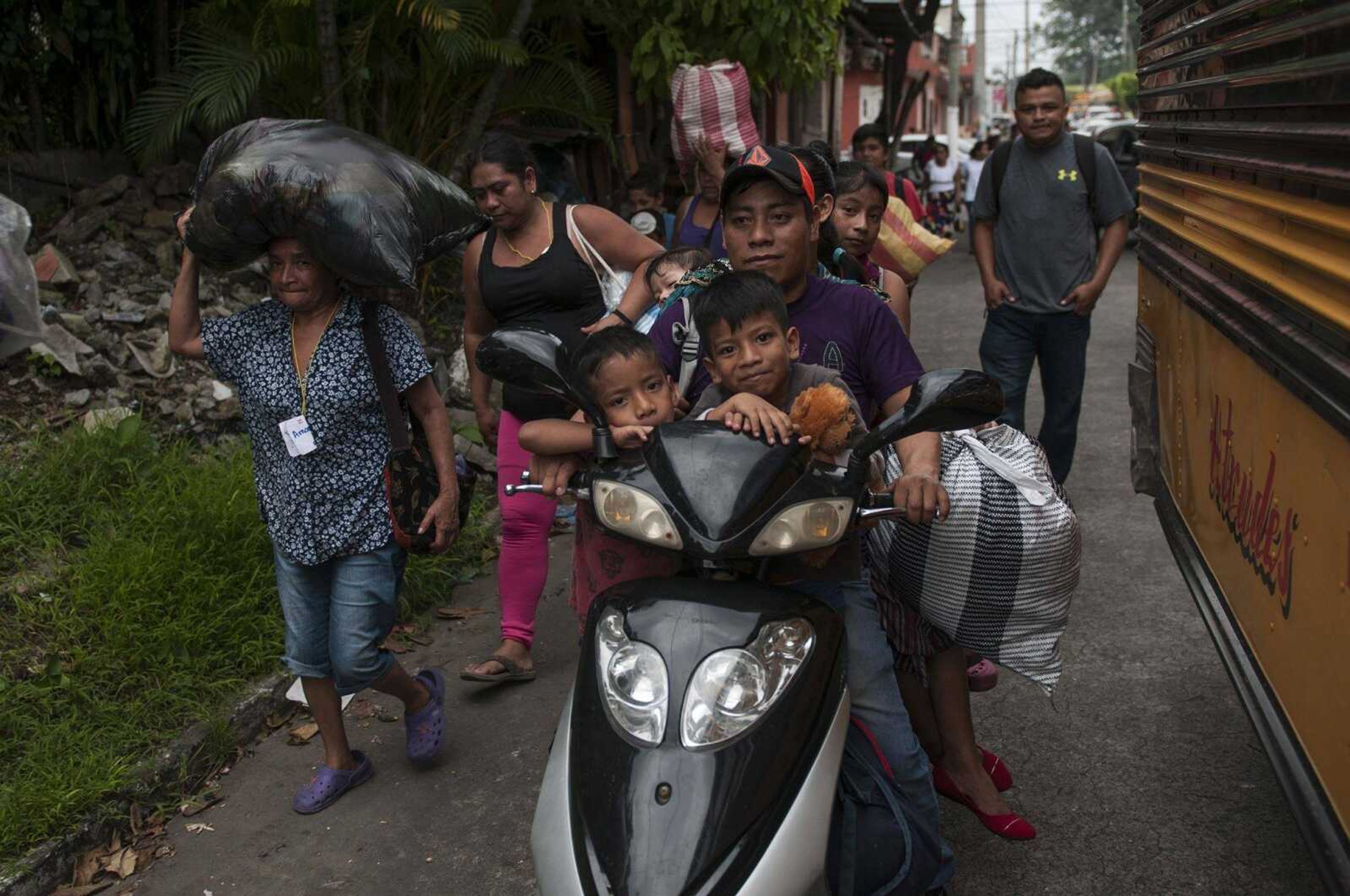 Residents evacuate Tuesday after a new flow of searing hot volcanic material moved down the slopes of the Volcano of Fire in Escuintla, Guatemala.