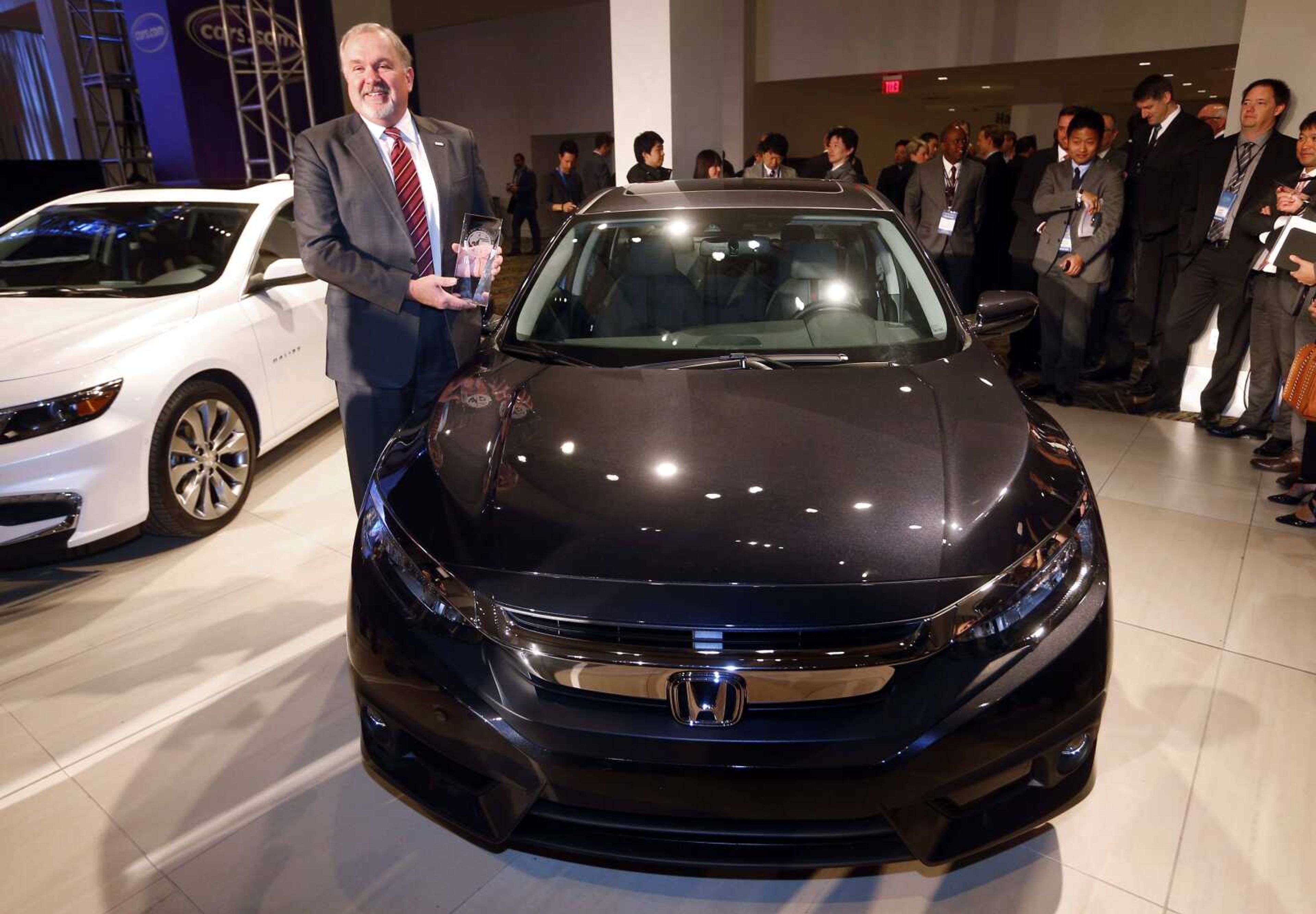 John W. Mendel, executive vice president of American Honda Motor Co. Inc., poses Monday with the Honda Civic, winner of the North American Car of the Year award in Detroit. (Paul Sancya ~ Associated Press)