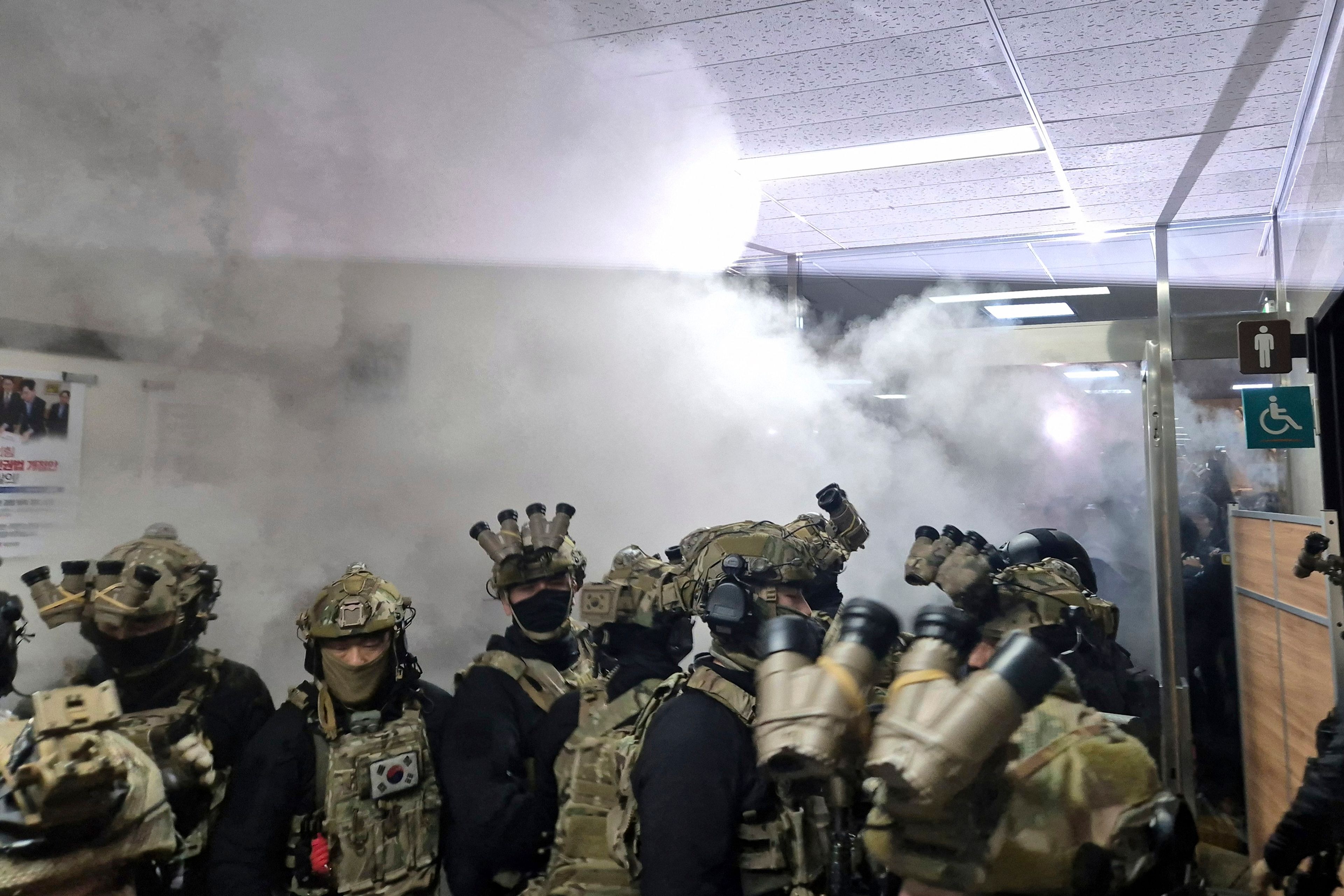 A National Assembly staff sprays fire extinguishers to block soldiers entering the main hall of the National Assembly in Seoul, South Korea, Wednesday, Dec. 4, 2024. (Jo Da-un/Yonhap via AP)