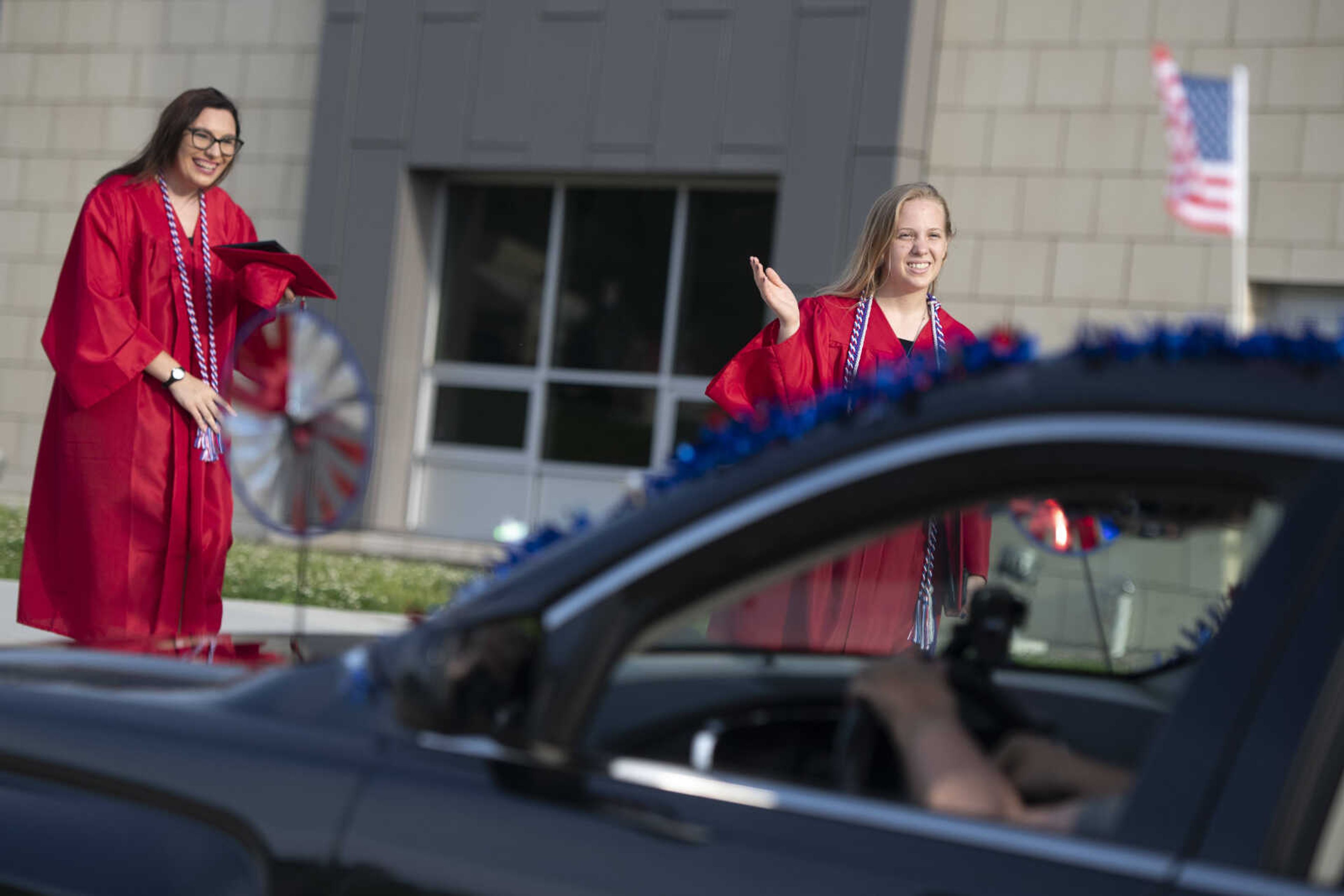 Jackson High School graduates Erin Taylor Huff (right) and Amber Marie Lowes smile during a parade following an in-person military graduation ceremony Friday, May 22, 2020, at Jackson High School.