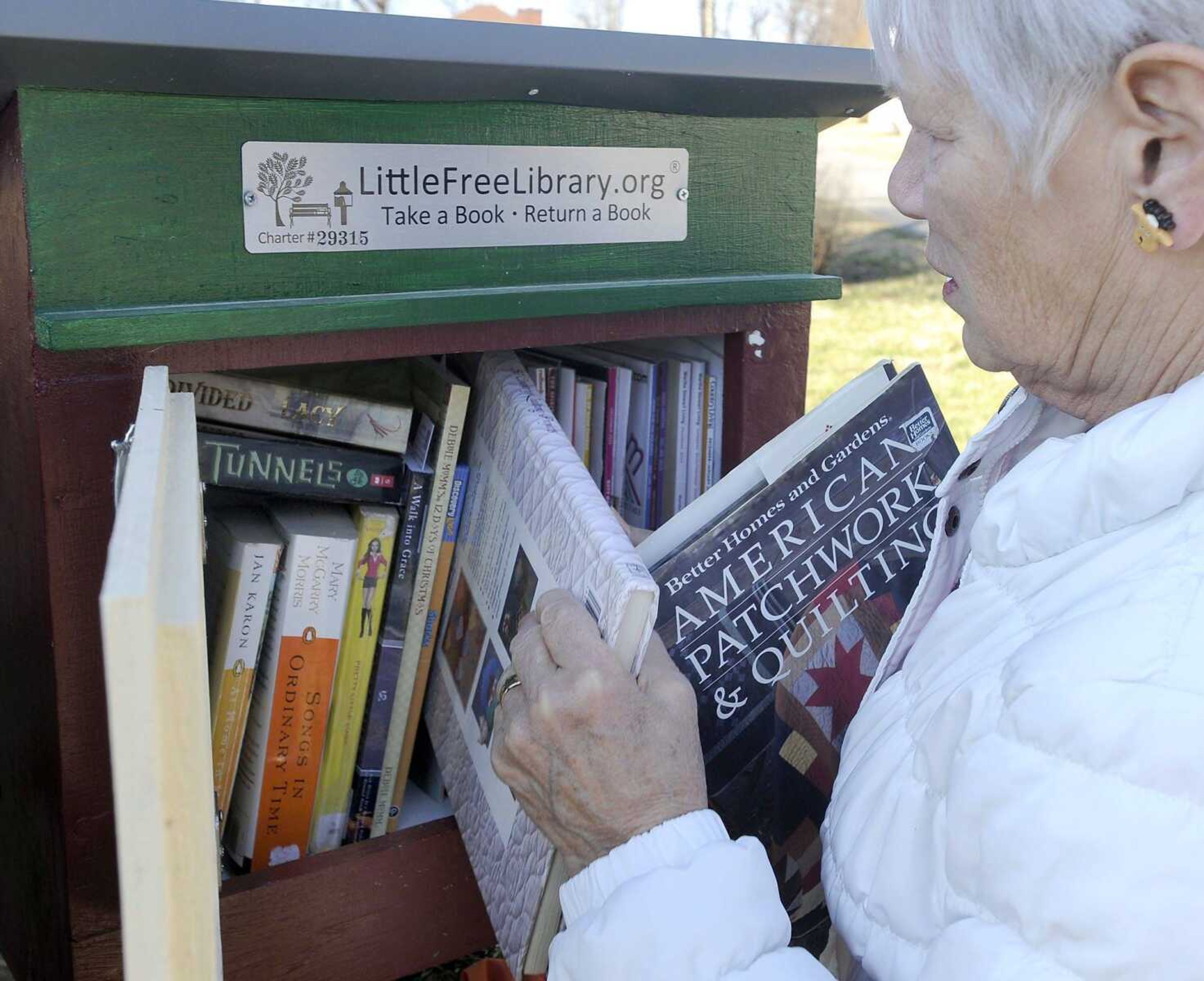 Doris Dace demonstrates the Little Free Library in Pocahontas, Missouri. (Fred Lynch)